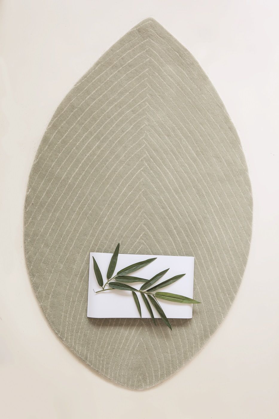 Blattförmiger Nanimarquina Teppich "Quill" in Grün mit Muster und Dekoration.