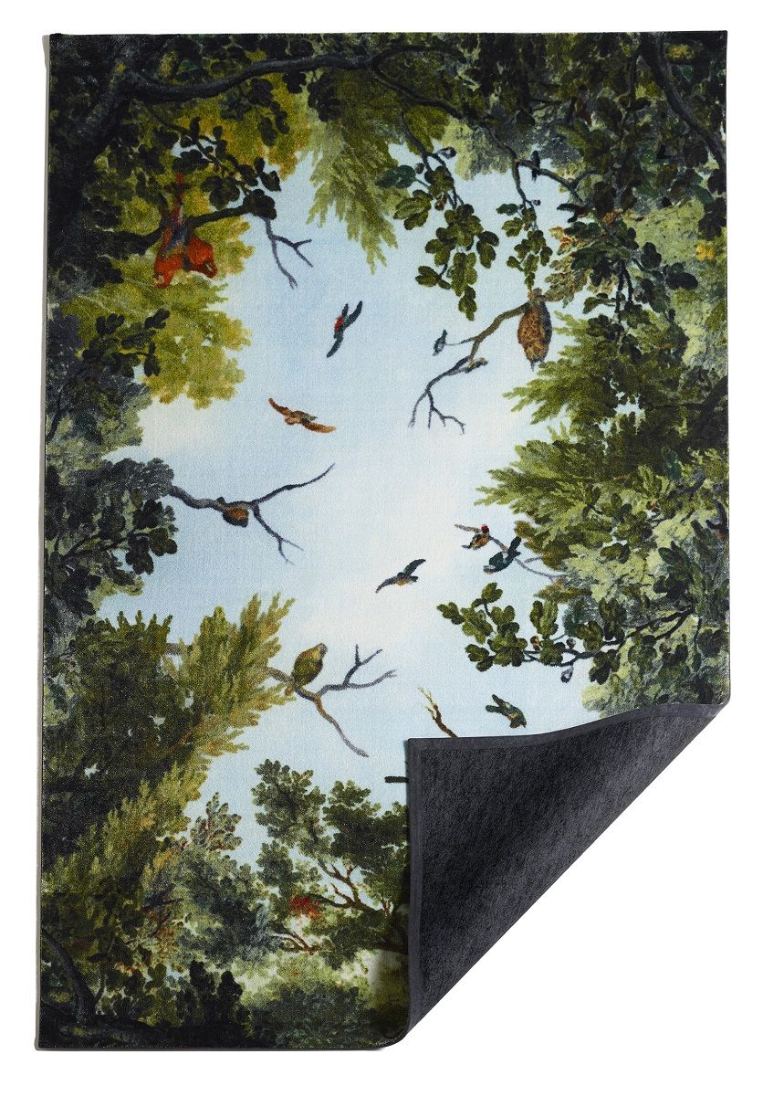 Cielo Teppich: Detailaufnahme des Teppichs mit Waldmotiv, Bäumen, Vögeln und hellem Himmel.