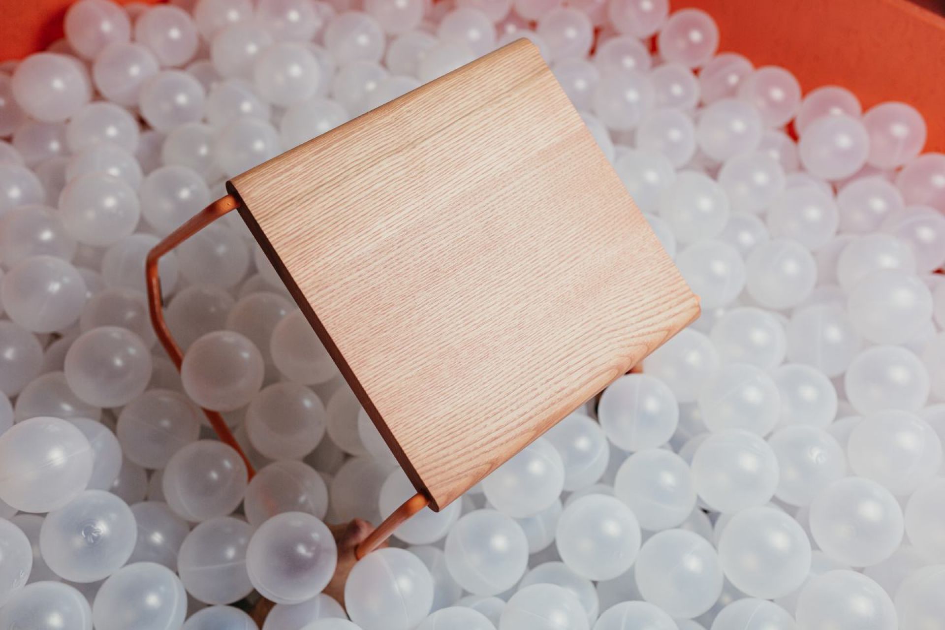 D:002 Beistelltisch Fuchs & Habicht aus Holz mit Metallgestell in einem Bällebad.