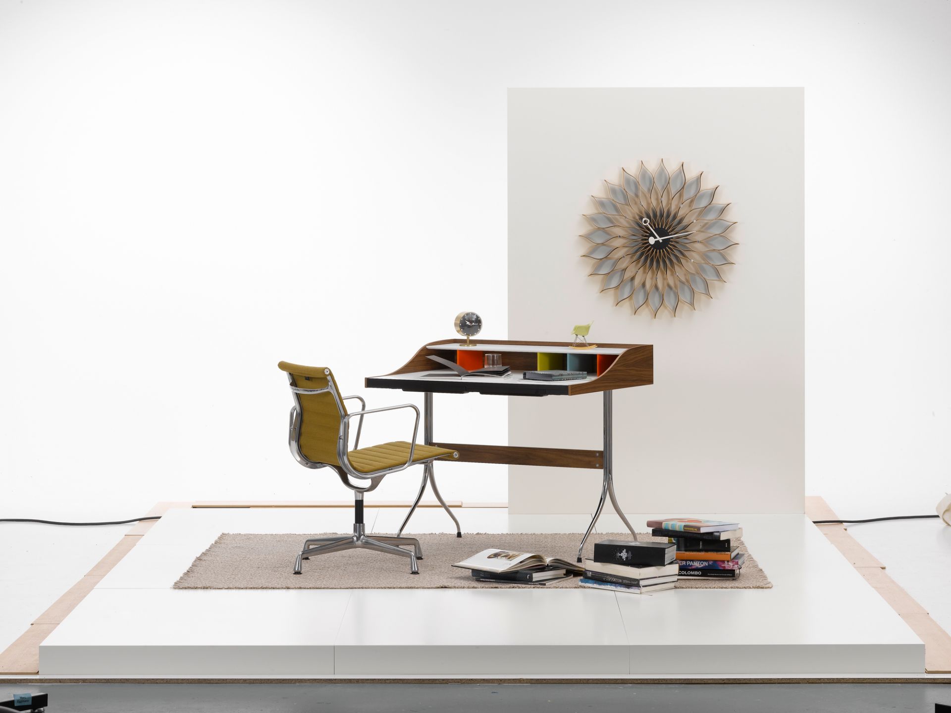 Vitra Home Desk mit Bürostuhl und Wanduhr in einem minimalistischen Studio-Setup. Moderner Schreibtisch für das Homeoffice.