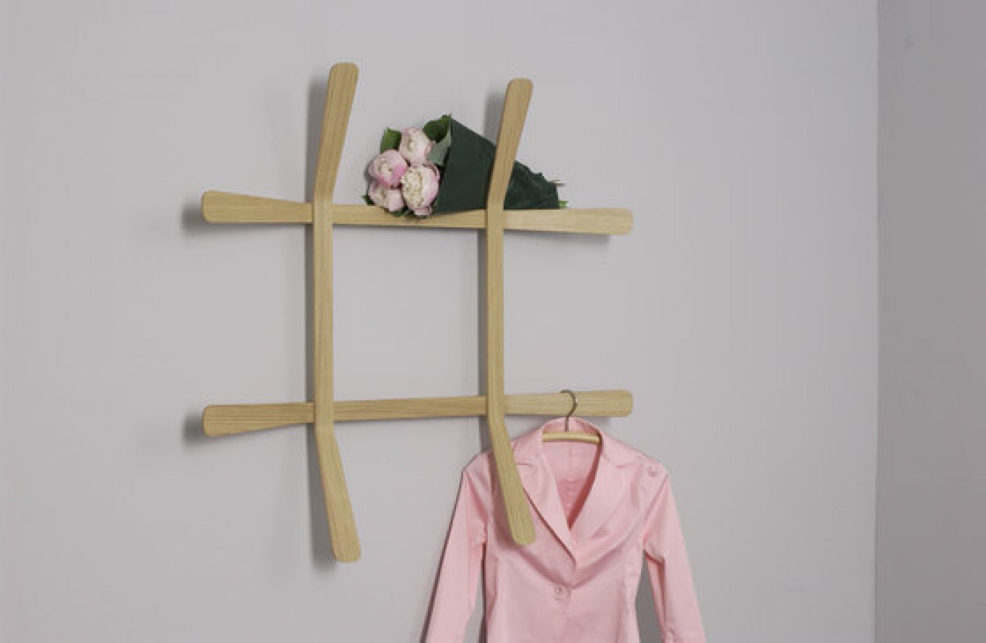 Lili Wandgarderobe aus Holz mit Jacke und Blumenstrauß, moderne Garderobenlösung für Flur und Schlafzimmer.