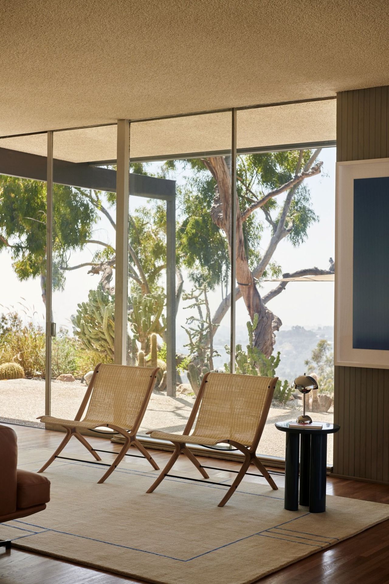 AndTradition Teppich Cruise AP11 in hellem Wohnzimmer mit Stühlen und großem Fenster.