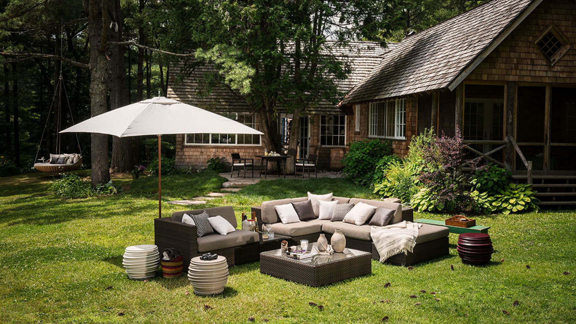 Dedon Lounge Modul rechts im Garten, mit Outdoor-Möbeln und Sonnenschirm.