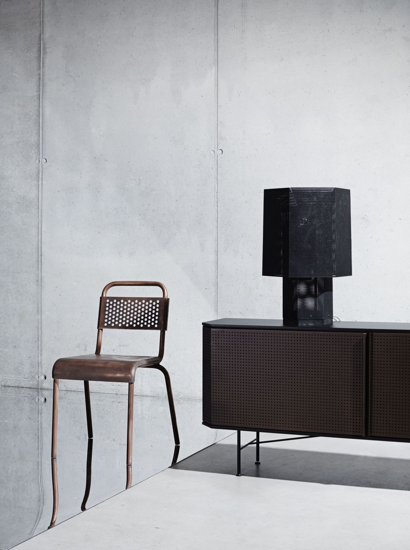 Nizza Stuhl von Moroso Diesel. Metallstuhl in Kupferoptik neben einem Sideboard mit Lampe.