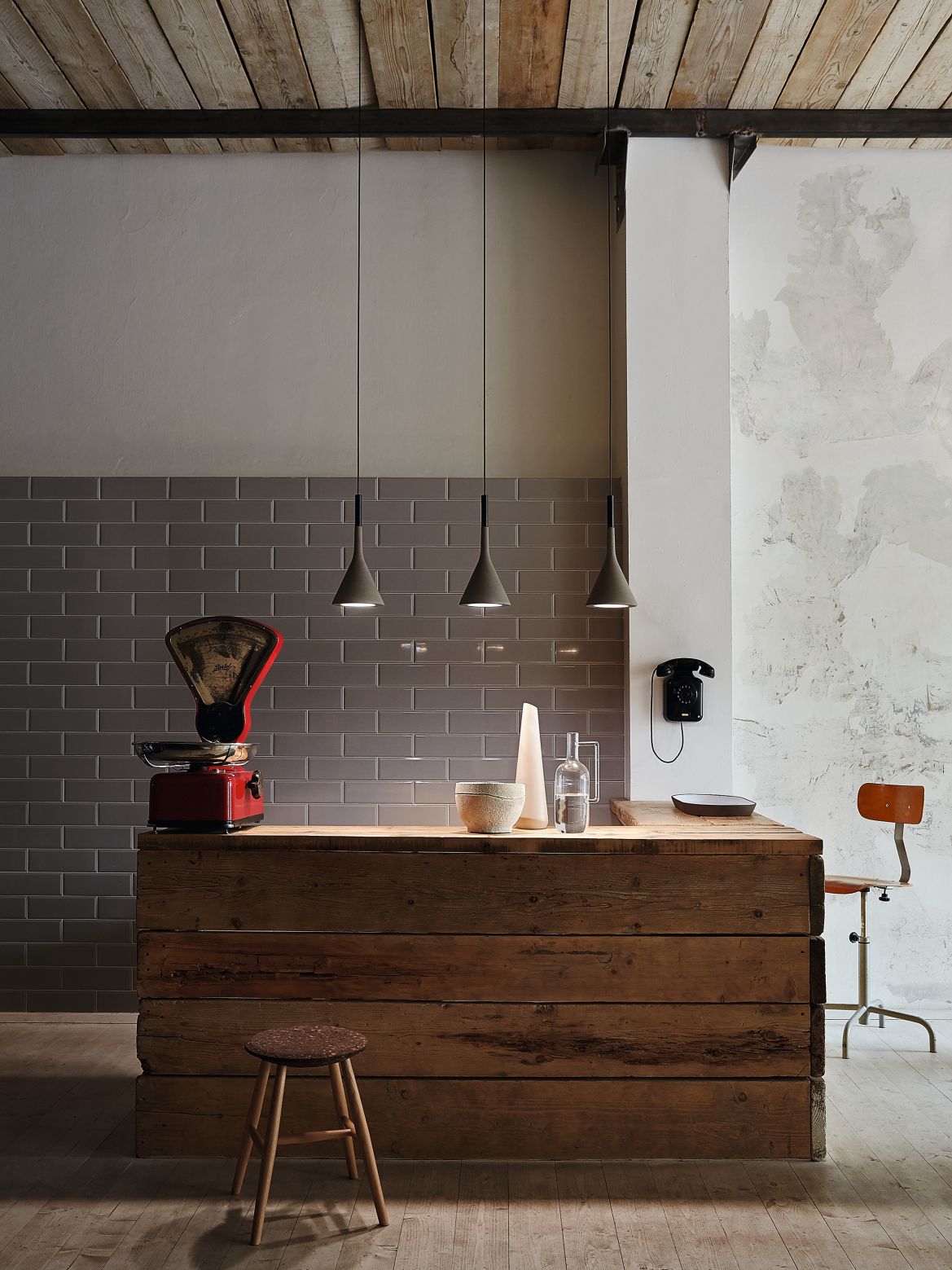 Drei braune Aplomb Pendelleuchten von Foscarini hängen über einer Kücheninsel aus Holz.