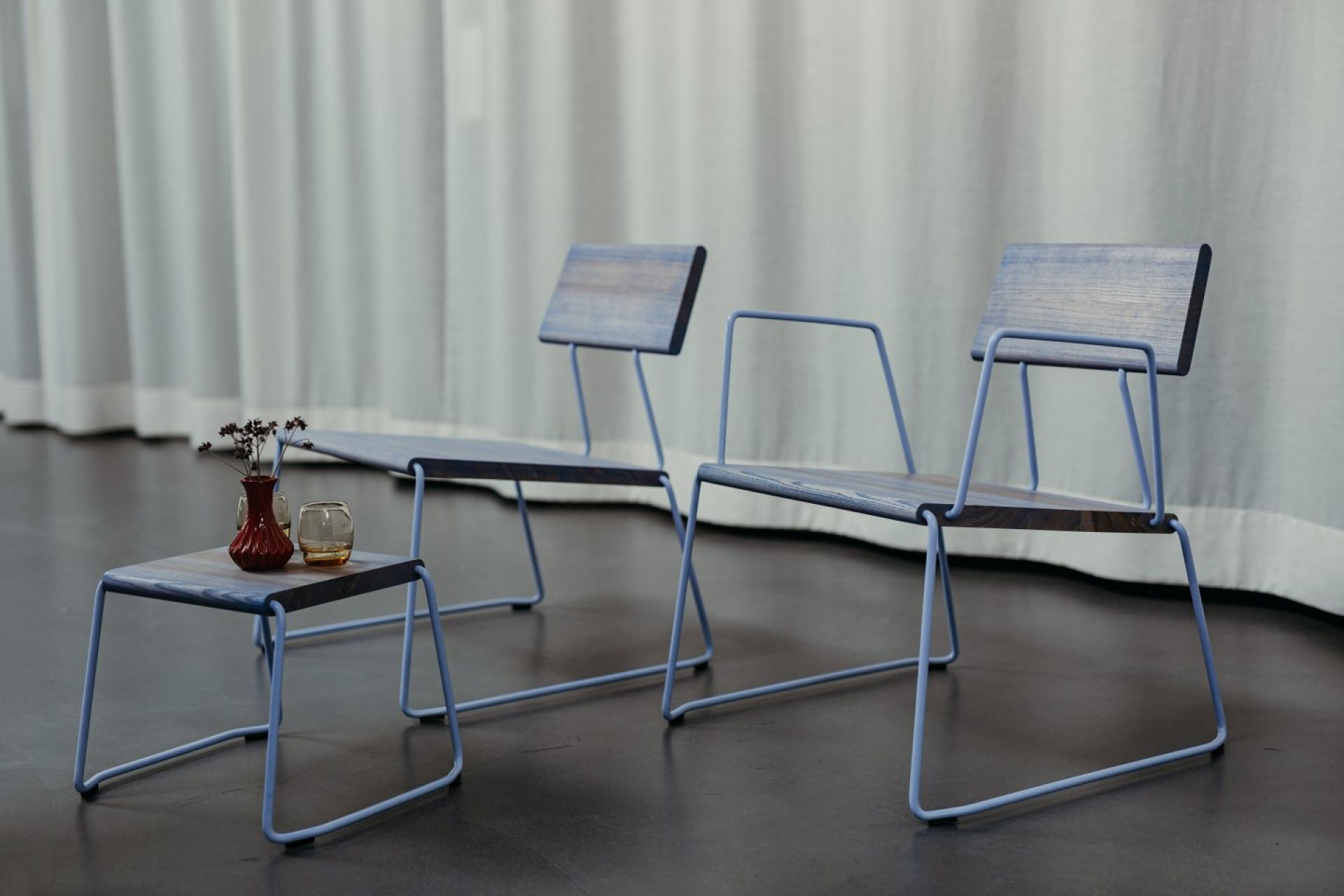 D:008 Loungechair mit Armlehnen von Fuchs & Habicht: Zwei blaue Holzstühle und Beistelltisch.
