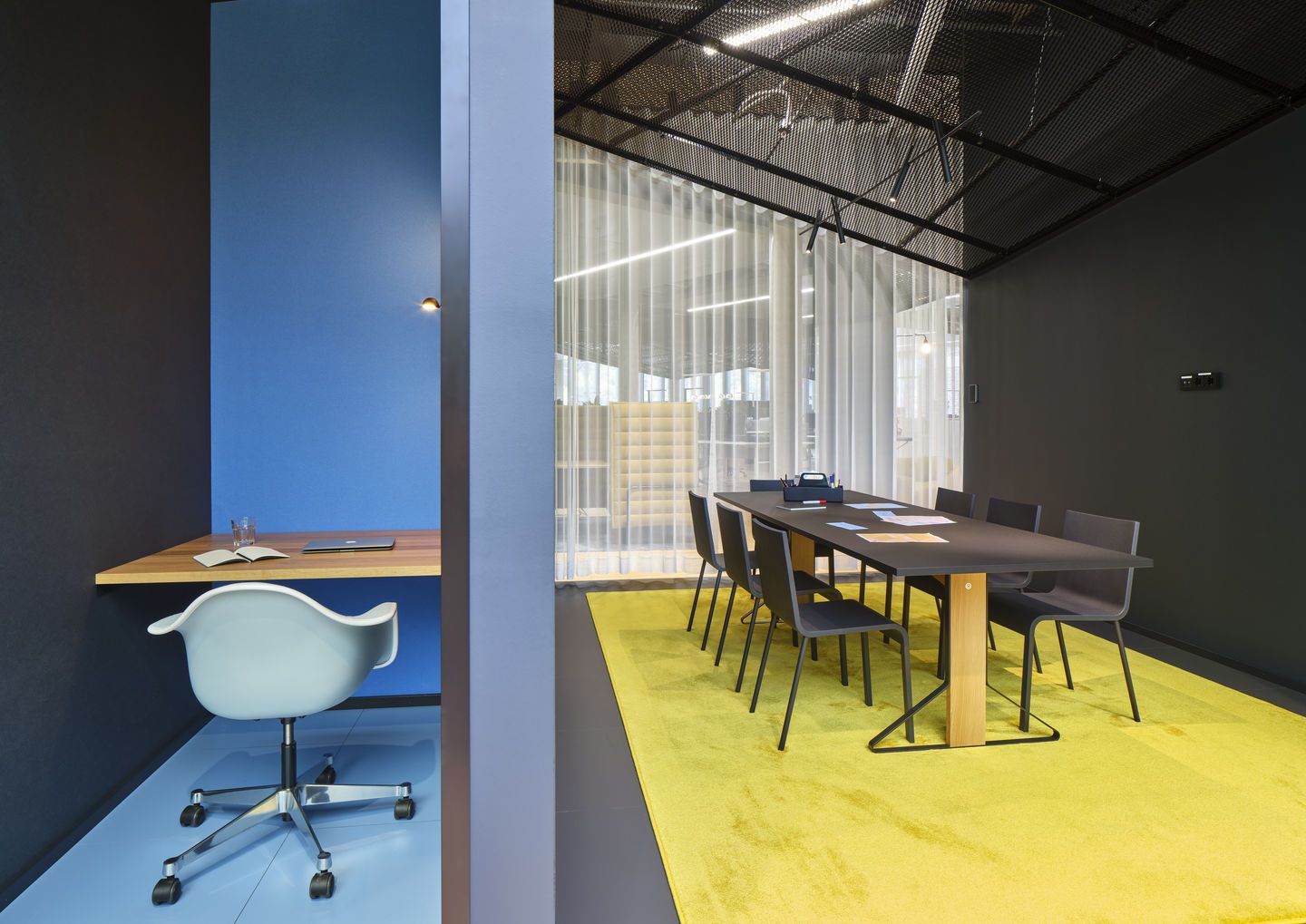 Eames Plastic Arm Chair PACC von Vitra, hellblau mit Sitzpolster, im modernen Büro.