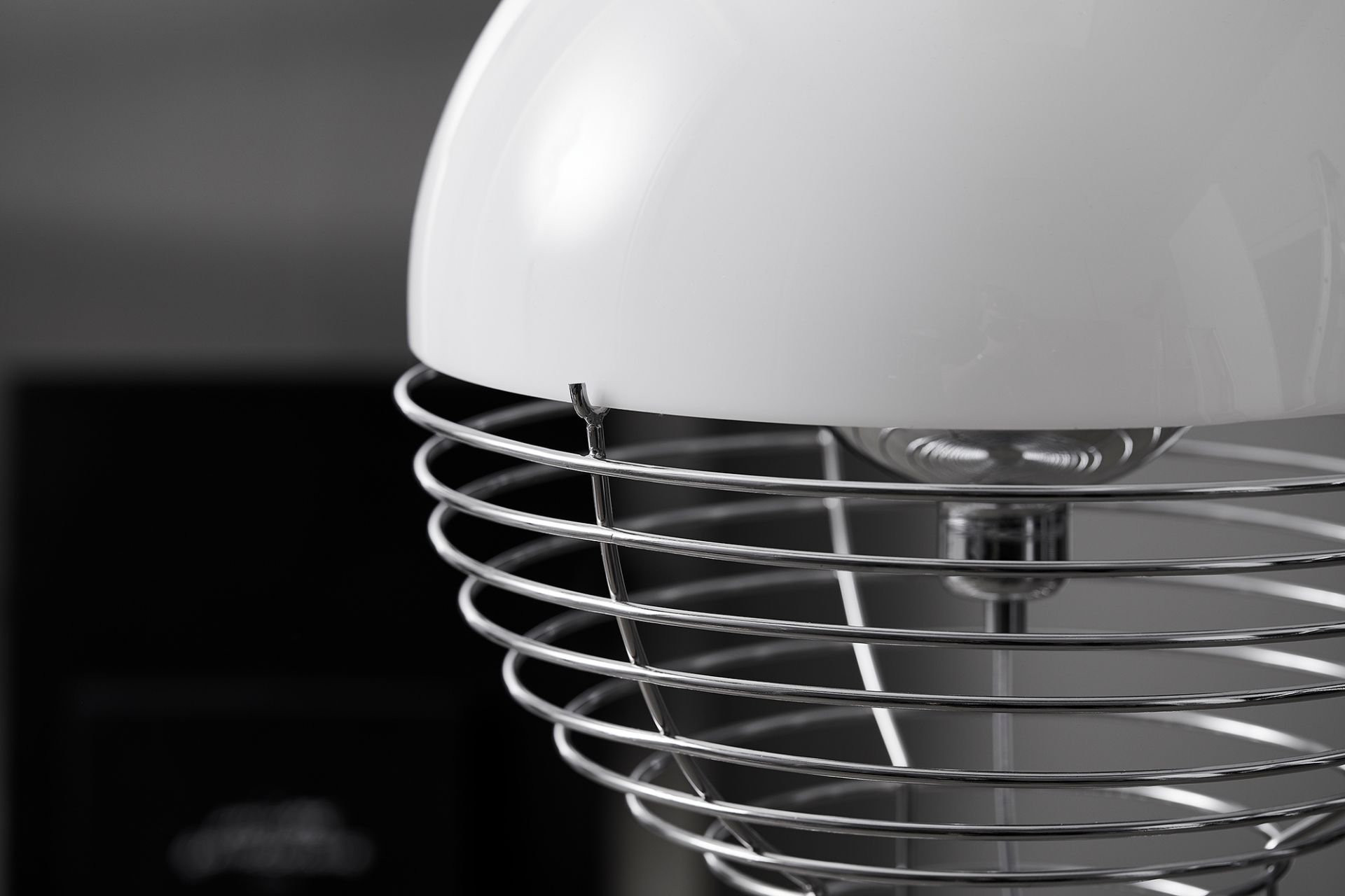 Detailaufnahme der Verpan Wire Stehleuchte mit weißem Schirm und filigranem Drahtgestell aus Chrom.