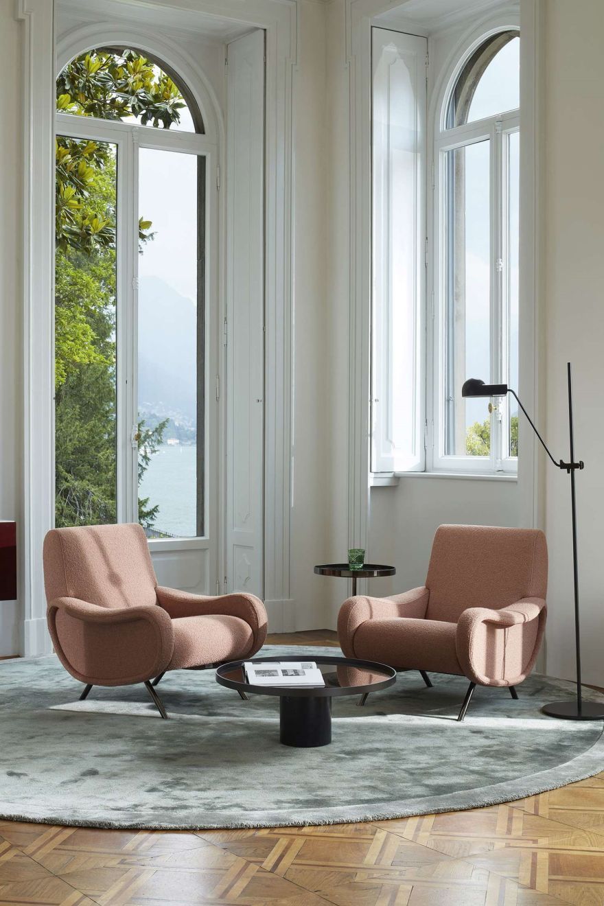 Zwei rosafarbene Cassina Sessel "Lady" in elegantem Interieur mit Teppich und Ausblick.