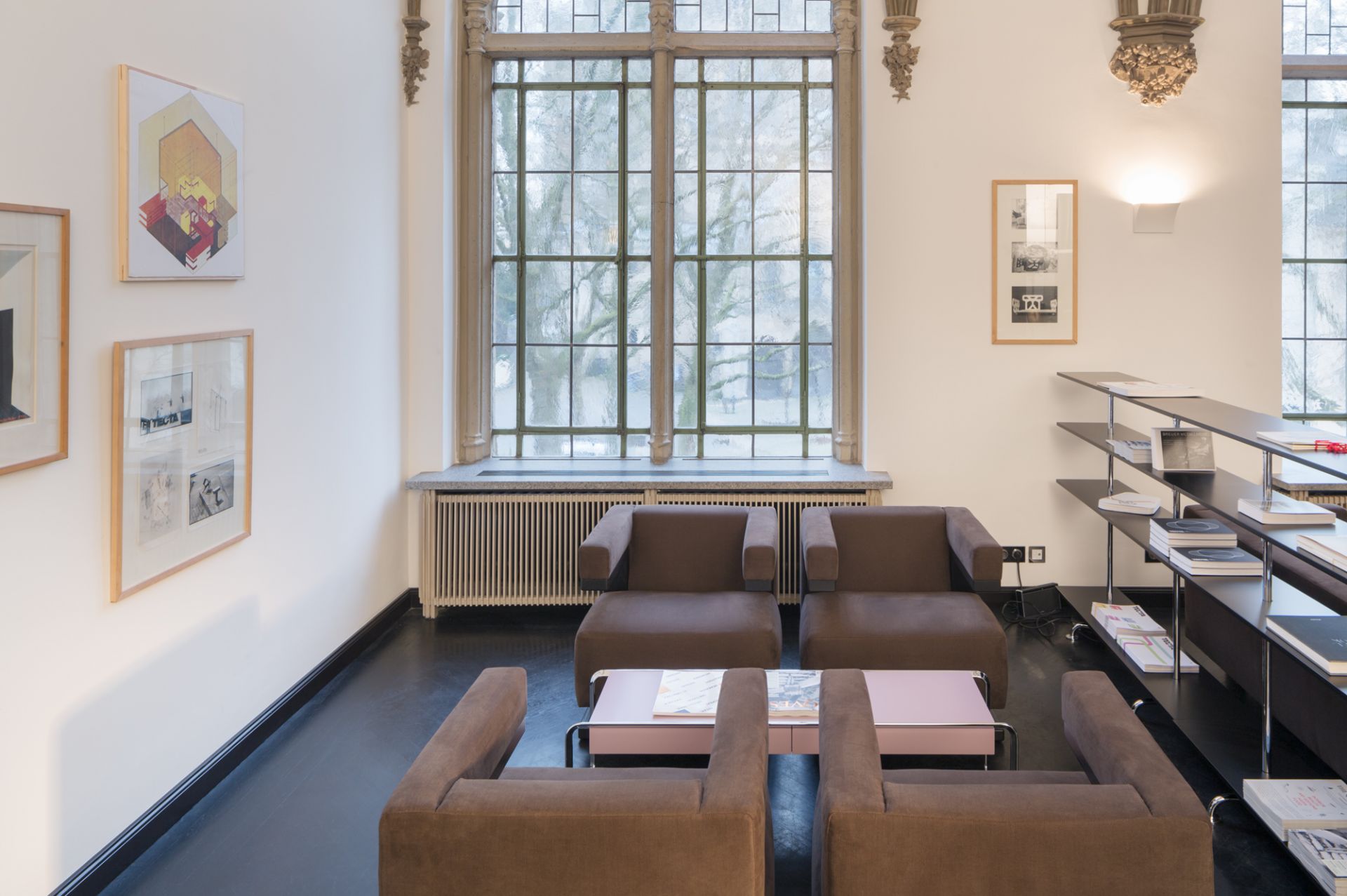 Innenaufnahme mit vier braunen Gropius F51 Sesseln im Bauhaus-Stil und einem rosa Tisch.