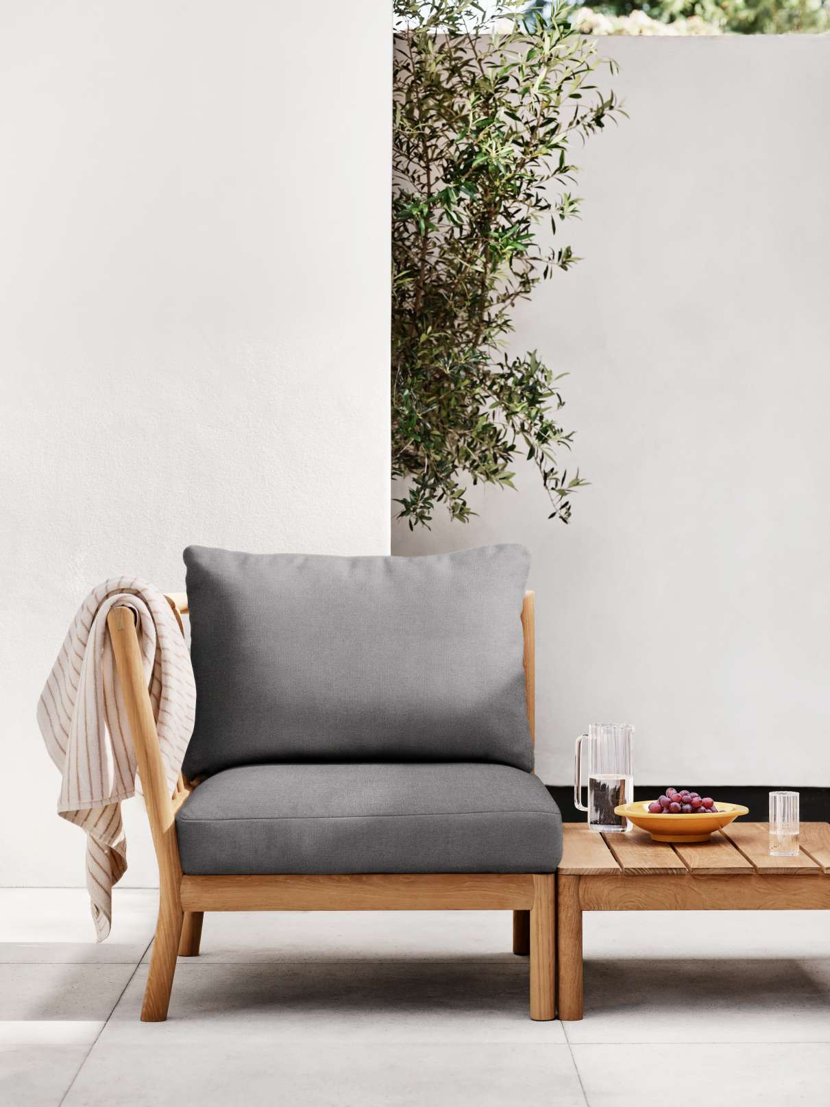 Tradition Lounge Tisch von Skagerak by Fritz Hansen aus Teakholz neben einem Loungesessel.