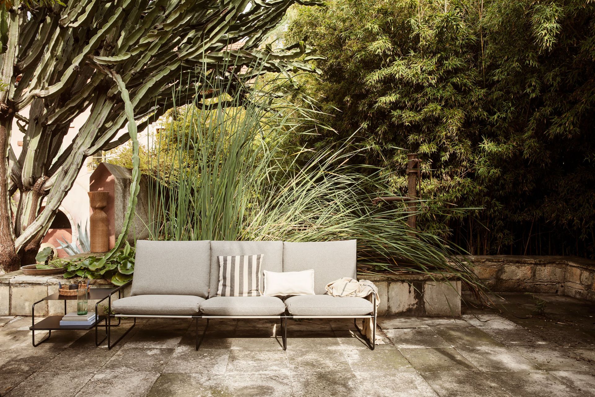 Desert 3-Sitzer Outdoor Sofa von Ferm Living mit Cashmere-Gestell im Garten.