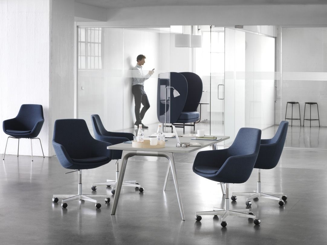 Büro mit mehreren blauen Fritz Hansen Sesseln, darunter der JH1001 Plenum Sessel, und einem Tisch.