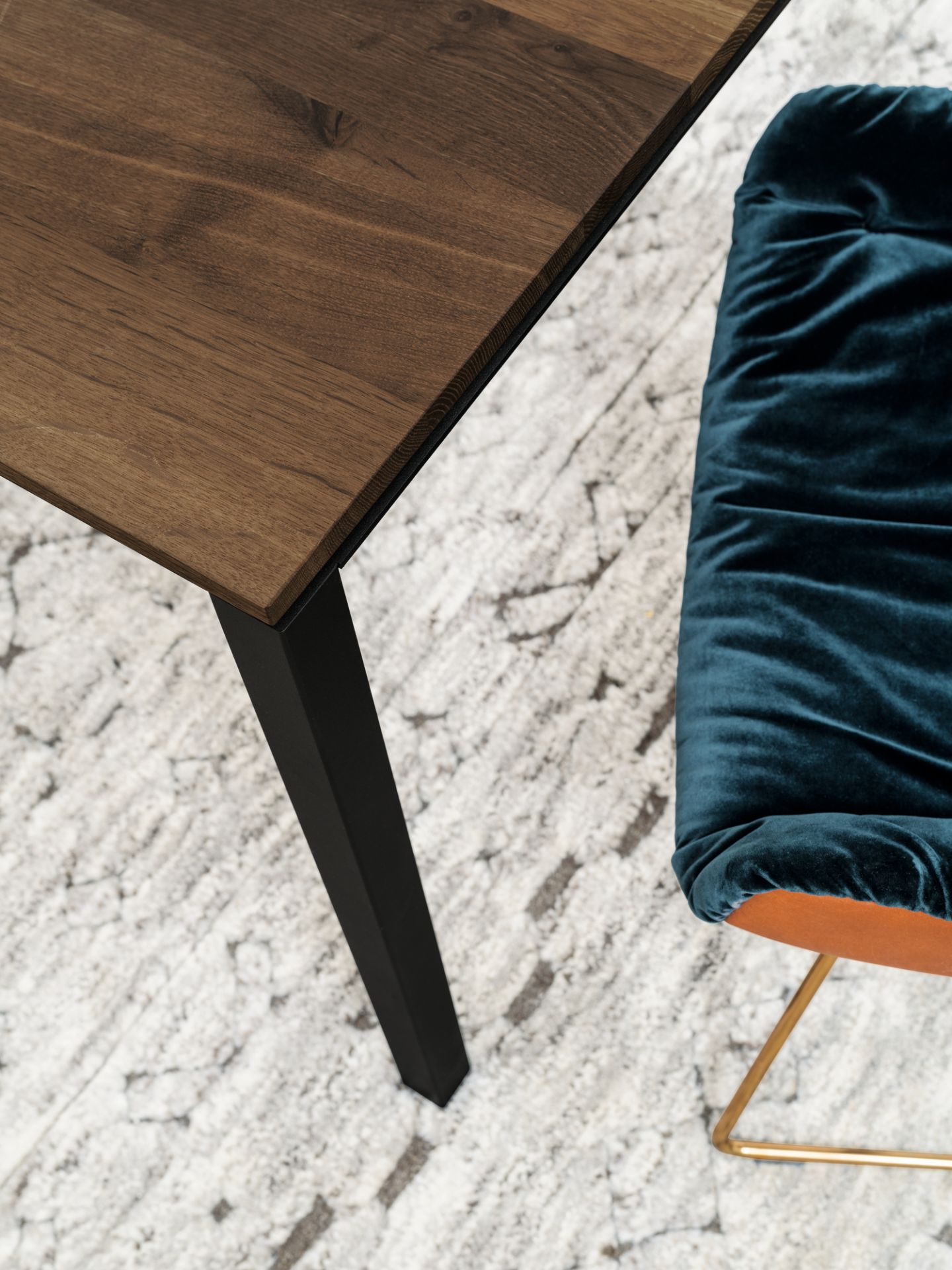 Detailaufnahme des Janua S 600 Tisches mit geräucherter Eichenplatte und schwarzem Metallgestell.