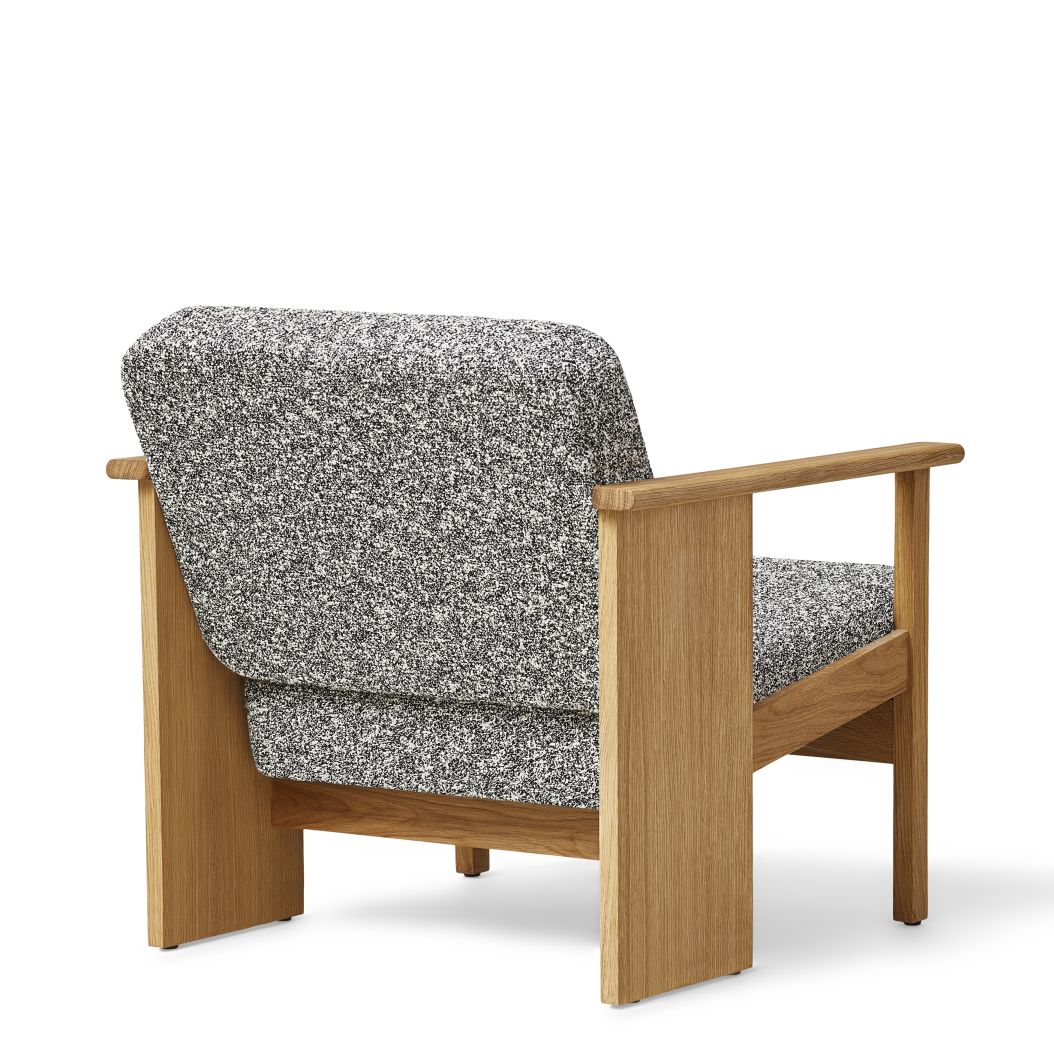 Block Lounge Sessel von Form & Refine mit grau-weiß melierter Polsterung und hellem Holzrahmen.