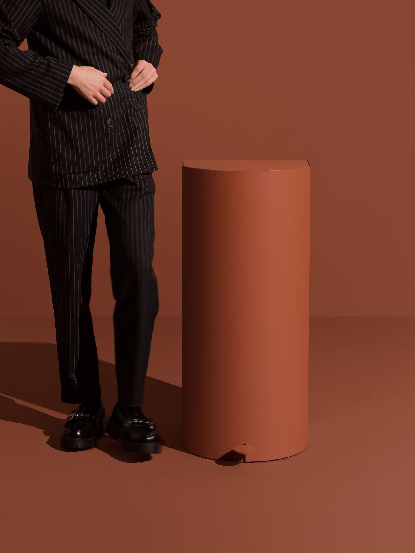 Pelican Pedal bin Treteimer: Runder, brauner Abfalleimer mit Fußpedal neben einer Person.