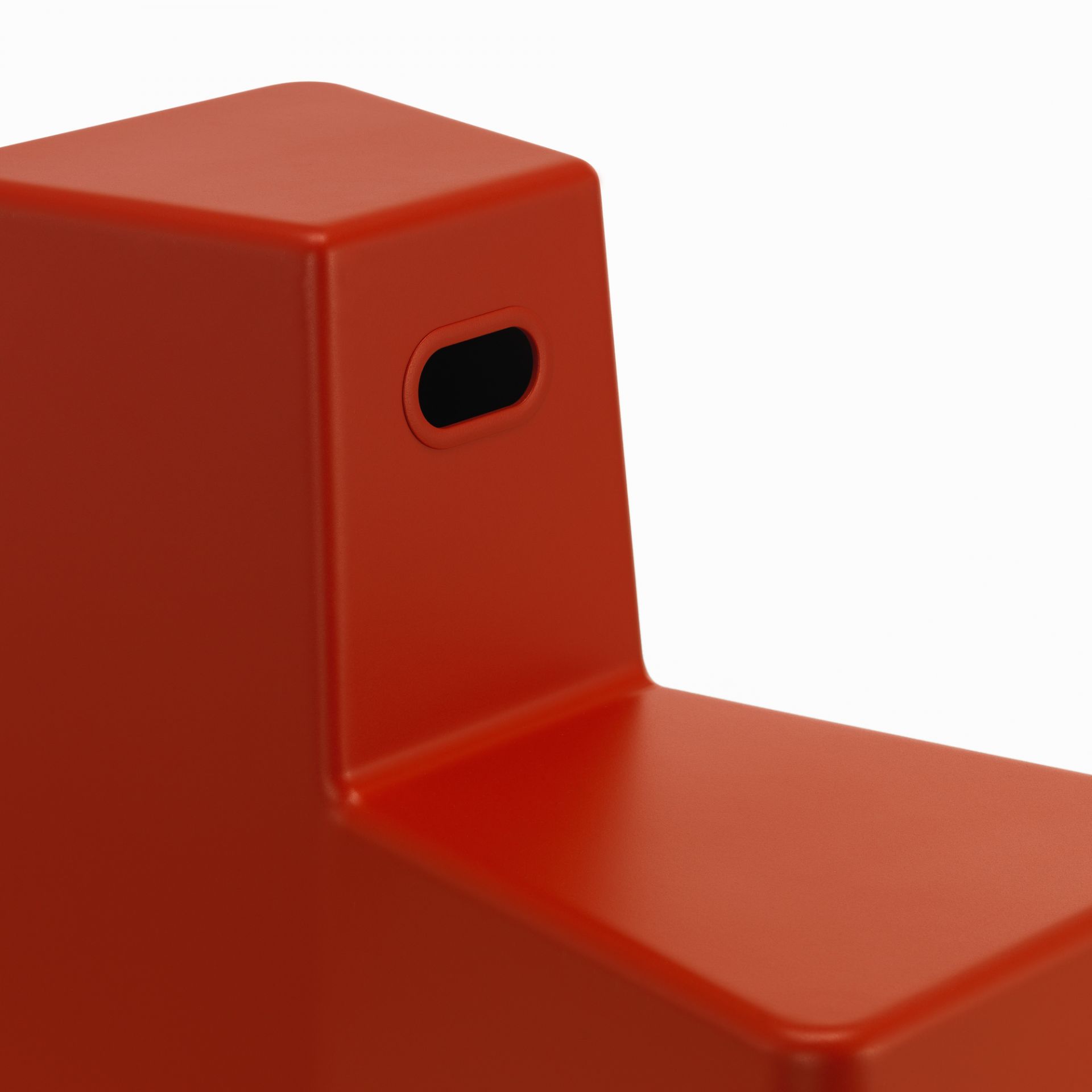 Detailaufnahme des roten Vitra Stool Tool Hockers mit praktischem Tragegriff. Moderner Hocker für Büro und Zuhause.