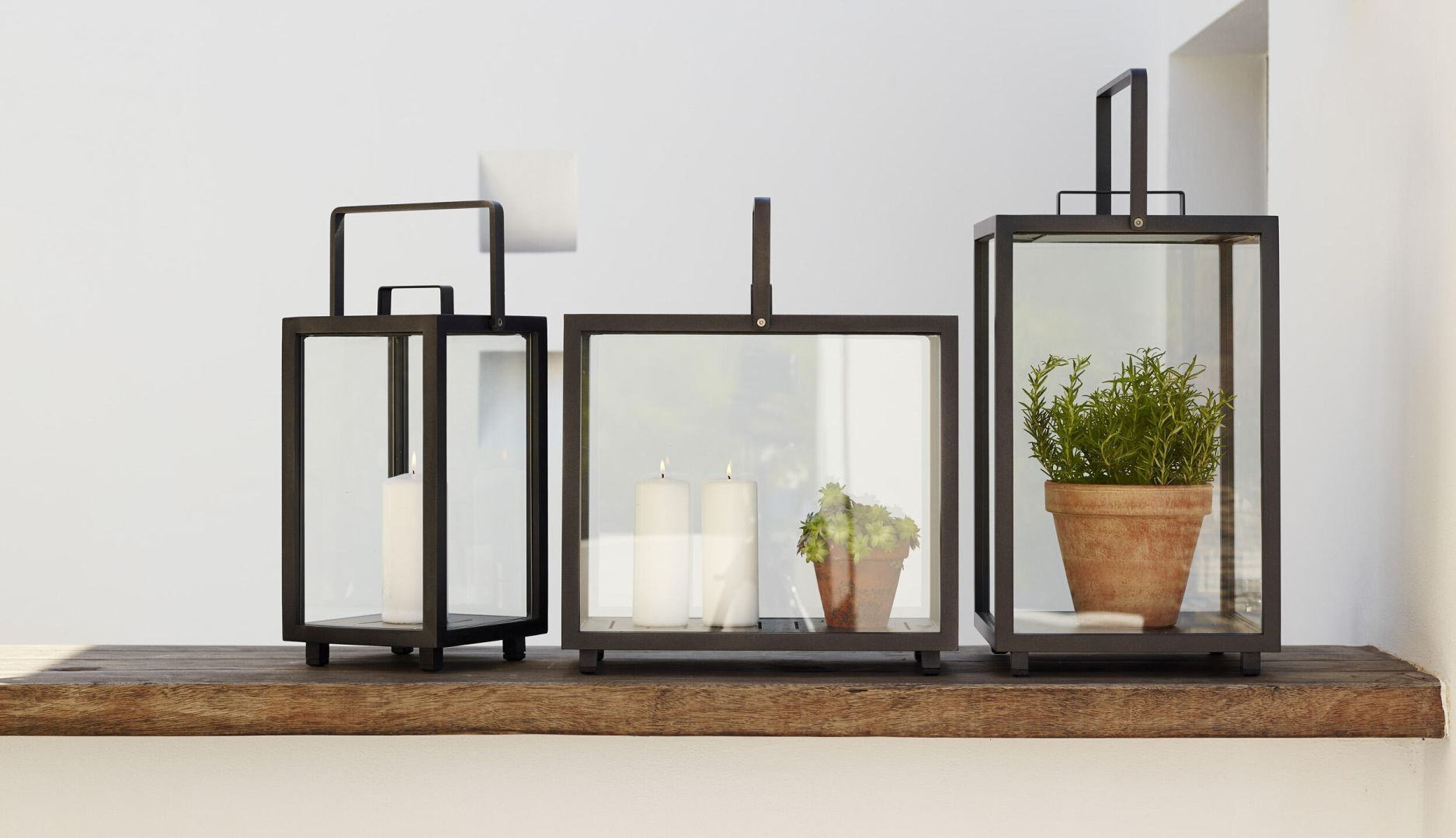 Rechteckige Lighthouse Laternen von Cane-Line aus Teakholz mit Kerzen und Pflanze im Innenraum.