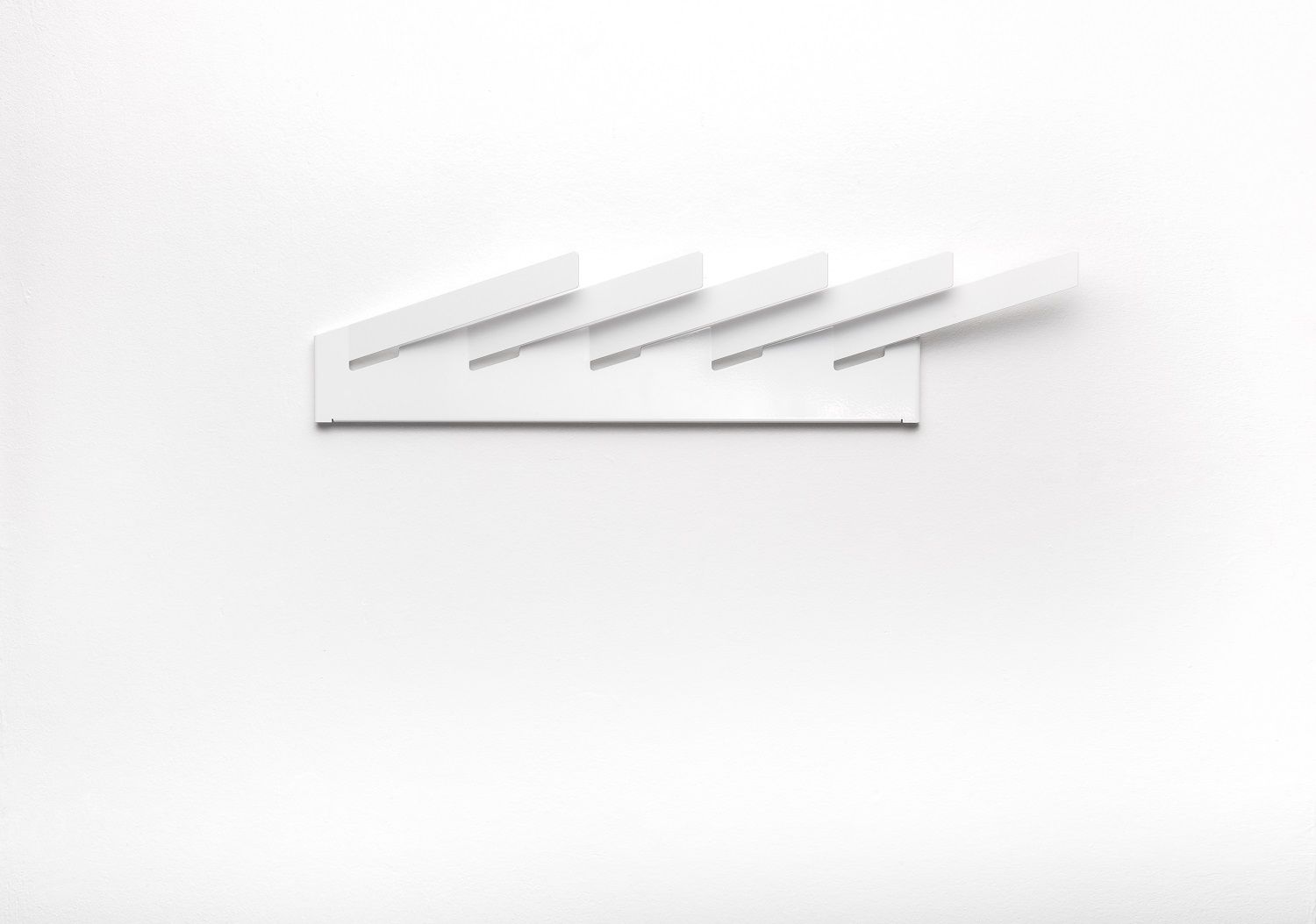 Weißer Mr_Magazinhalter von Müller Möbelwerkstätten an einer weißen Wand. Modernes Design für Zeitschriften und Magazine.