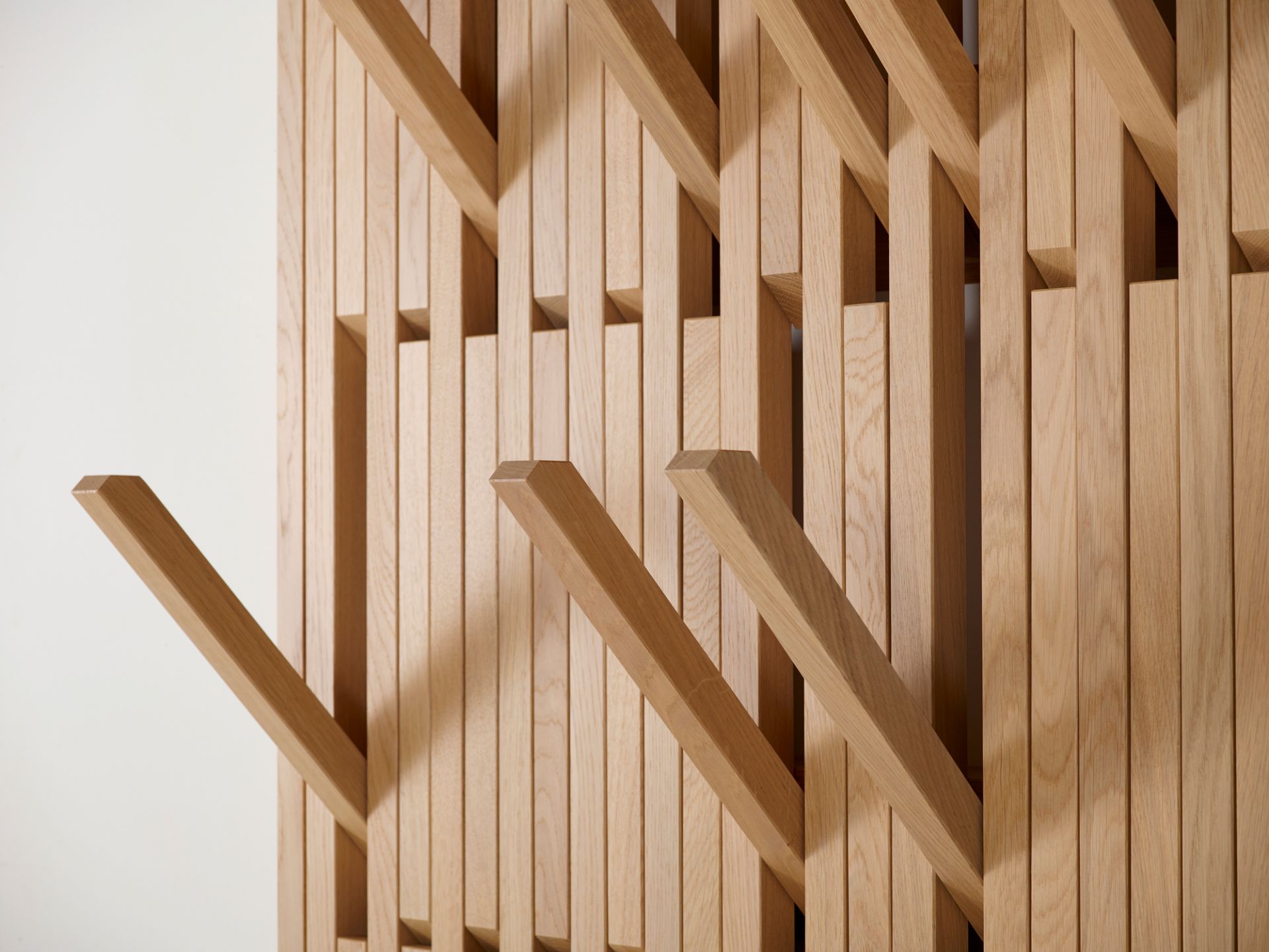 Detailaufnahme: Piano Wandgarderobe aus Eiche Natur geölt, moderne Holzgarderobe mit ausklappbaren Haken.