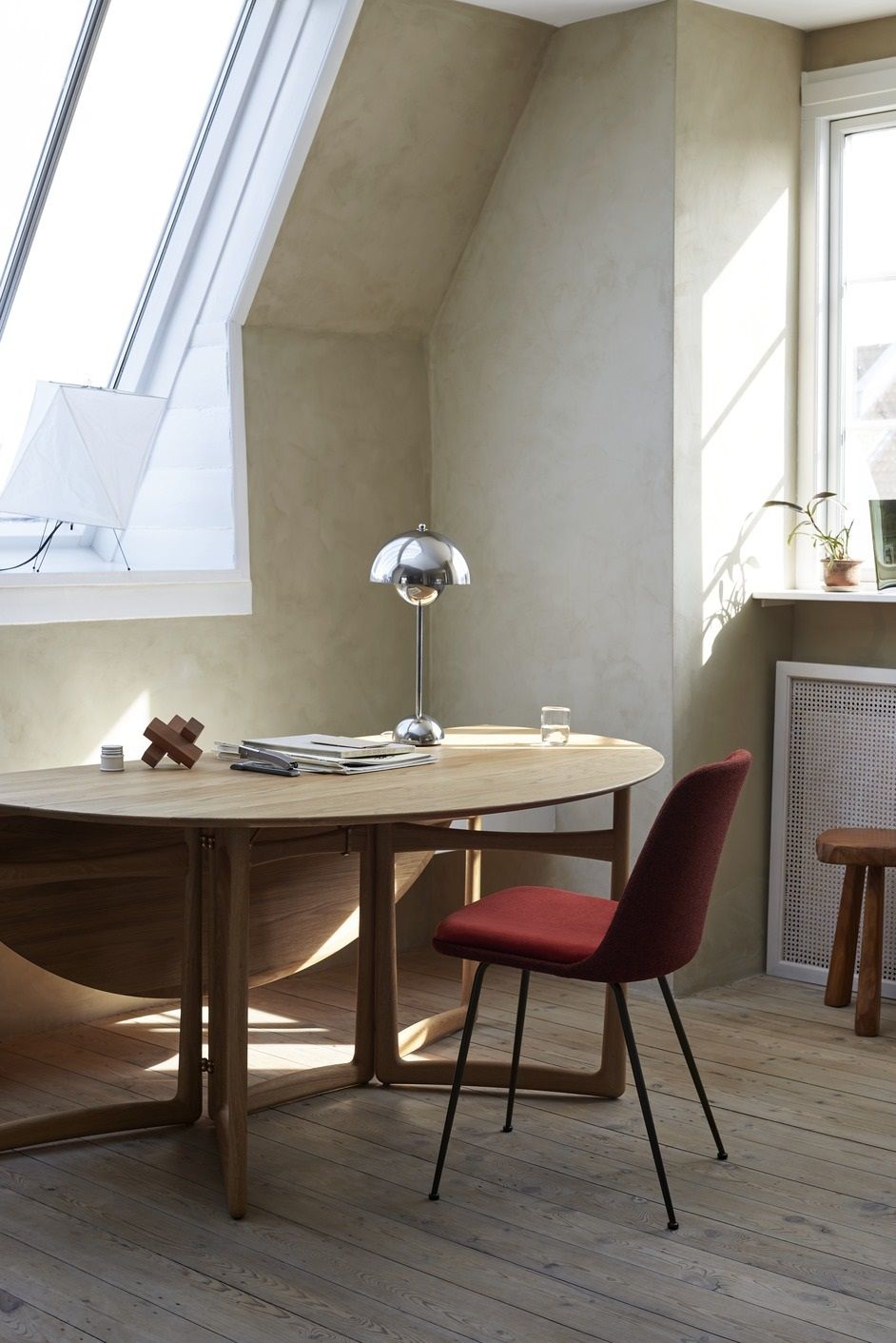 AndTradition Drop Leaf Esstisch HM6 aus Holz, mit rotem Stuhl in hellem Raum.