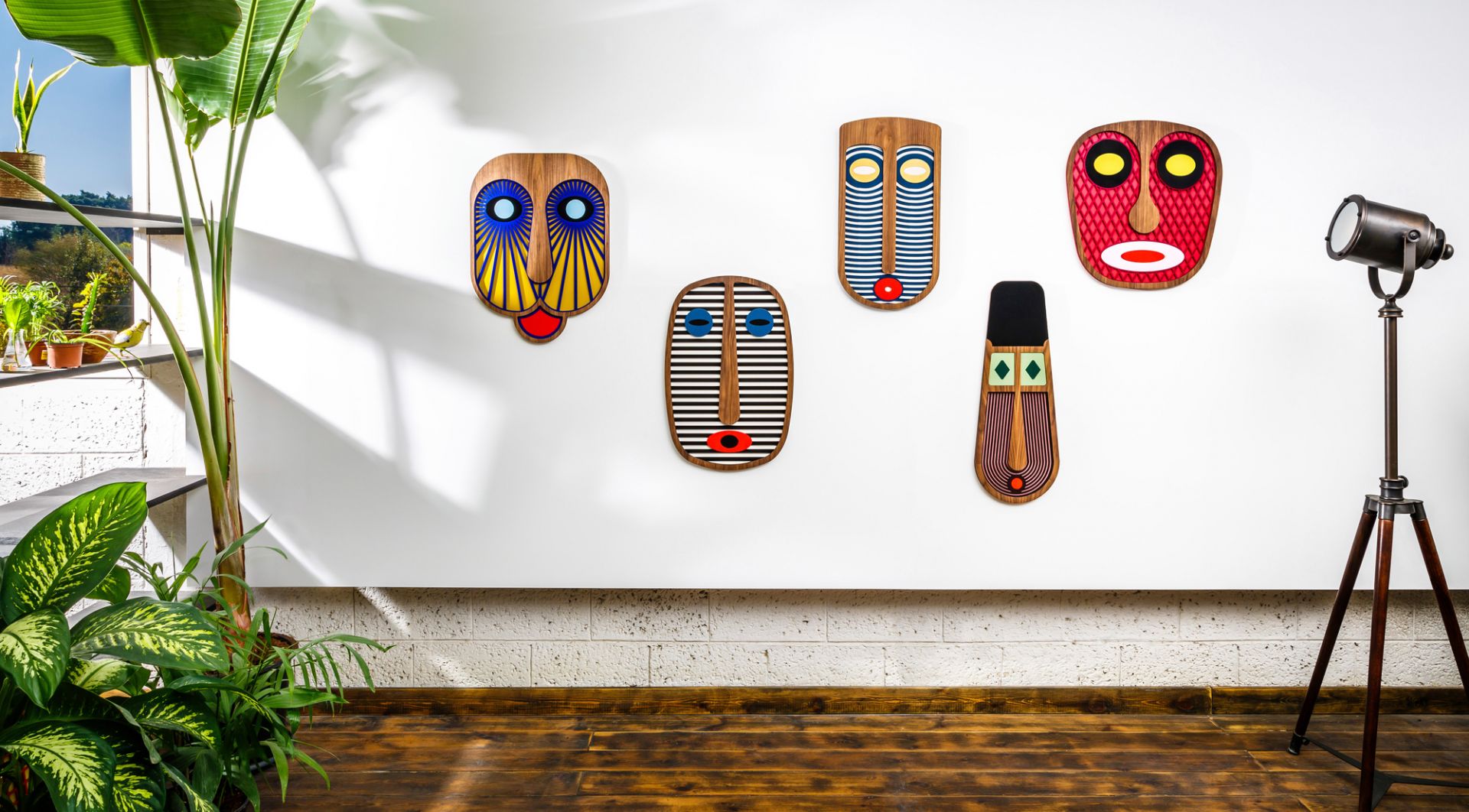 Fünf moderne afrikanische Masken als Wanddeko von Umasqu, farbenfrohe Holzkunst für stilvolles Wohnen.