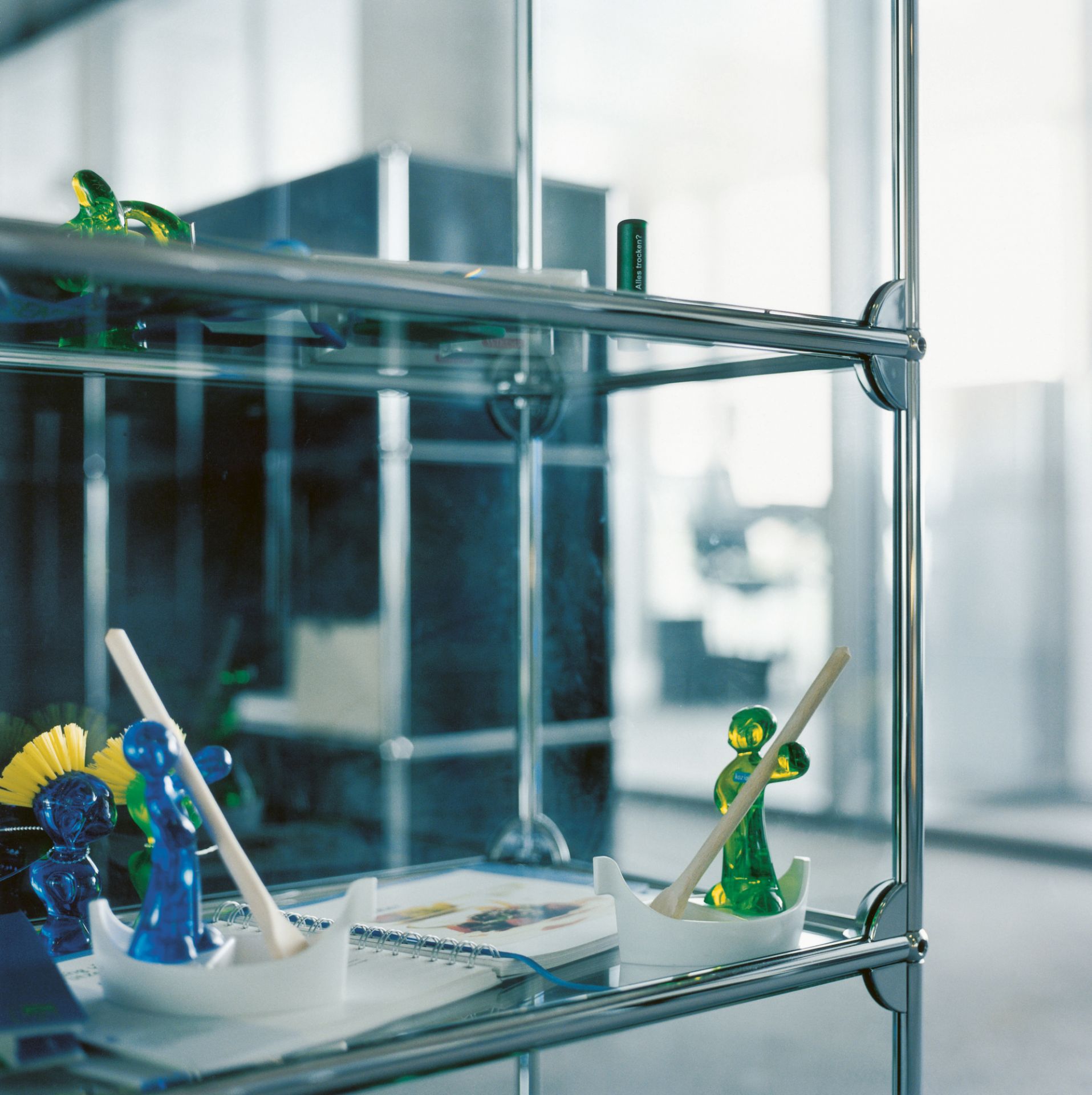 USM Haller Vitrine mit Glasböden und Deko-Objekten, ideal für Wohnzimmer und Büro.