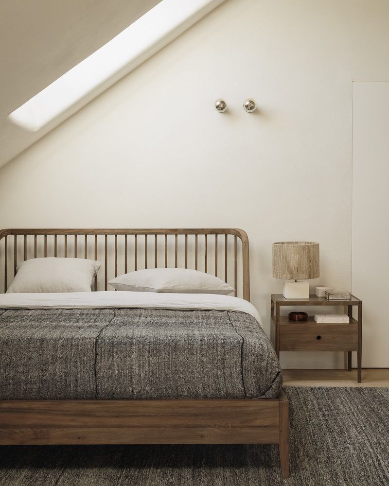 Nachttisch Spindle von Ethnicraft aus Teakholz mit einer Schublade neben einem Bett.