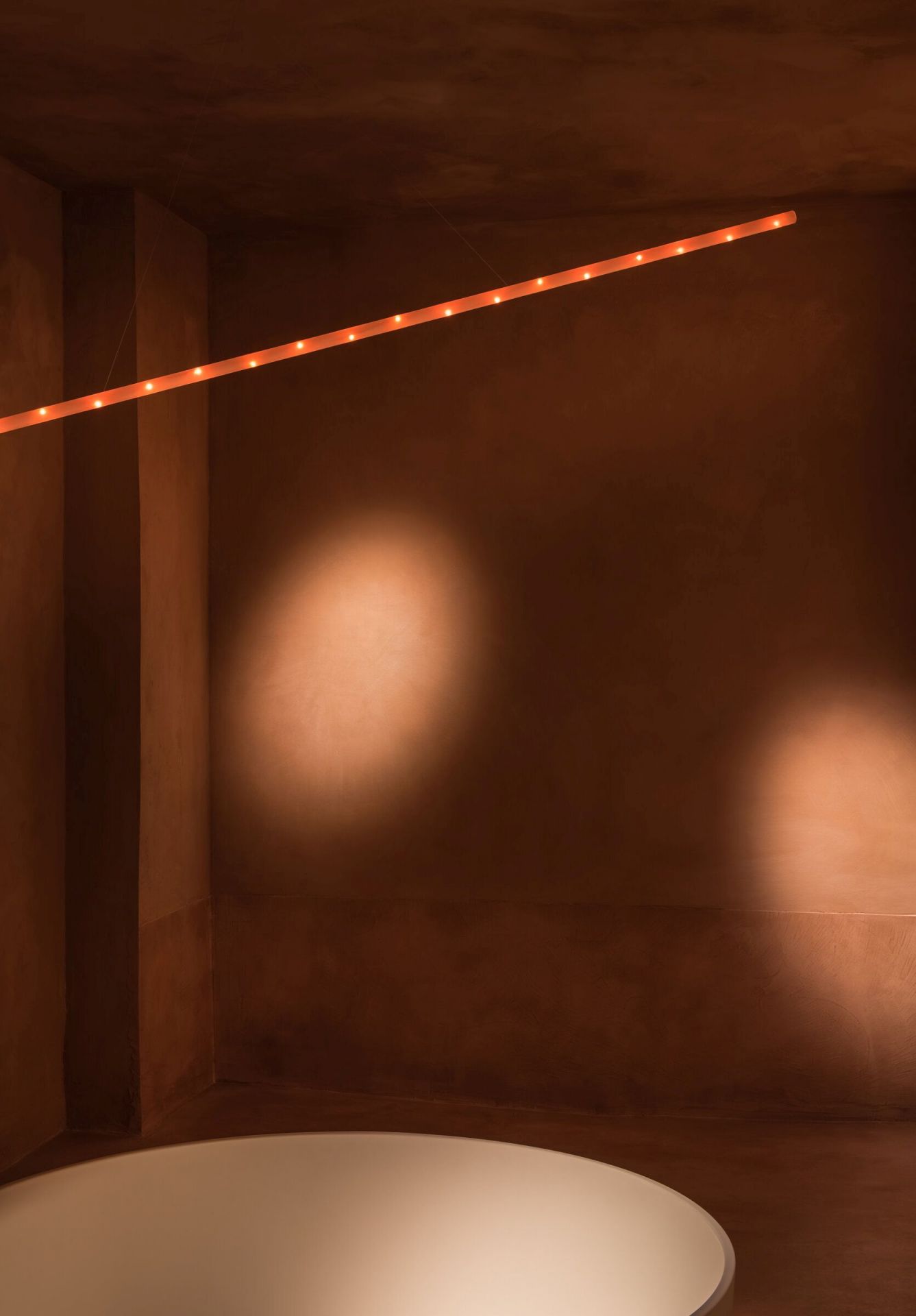 La Colilla Pendelleuchte von Santa & Cole, lineares Design mit warmem Licht im Raum.