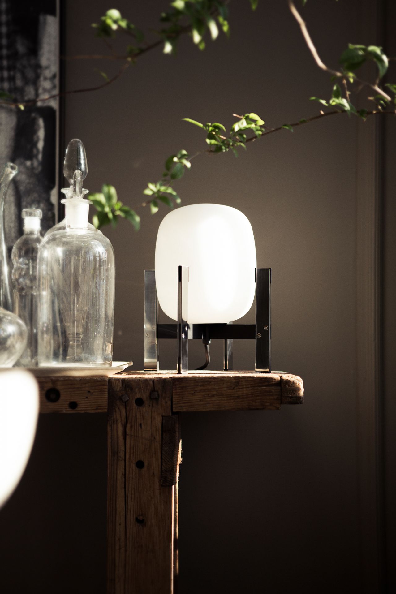 Cestita Metálica Tischleuchte von Santa & Cole auf einem Holztisch, moderne Tischlampe mit Metallgestell.