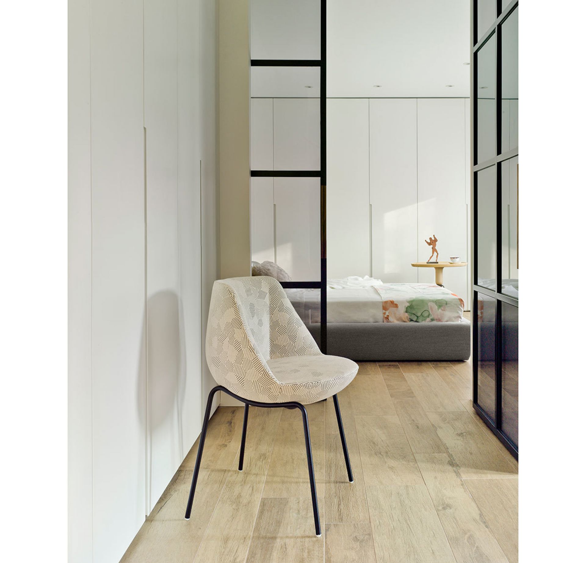 Magnum Stuhl mit anthrazitfarbenem Stahlgestell und gemustertem Bezug im modernen Schlafzimmer.