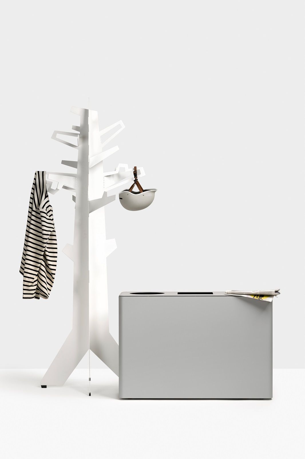 Dunk 3 Abfalltrennsystem: Grauer Mülleimer mit zwei Fächern neben weißer Garderobe mit Kleidung.