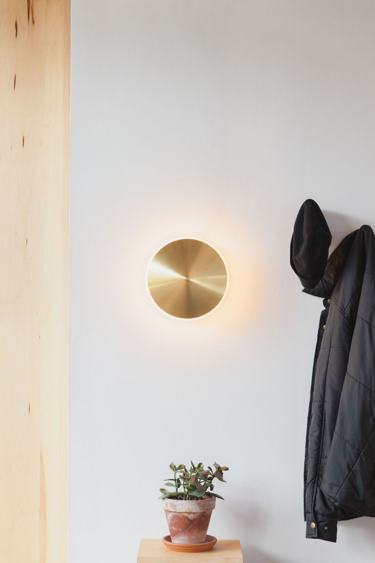Sconce10 Wandleuchte von Graypants aus Messing an weißer Wand, warmes Licht, minimalistisches Design.