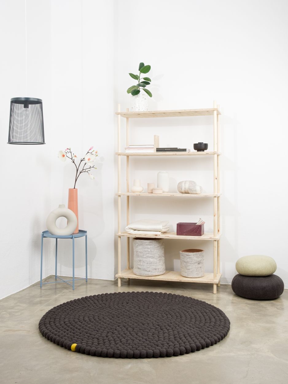 Anthrazitfarbener, runder Filzteppich "Big One" von myfelt (Ø 300 cm) im modernen Wohnraum. Hochwertiger Teppich aus Filzkugeln.