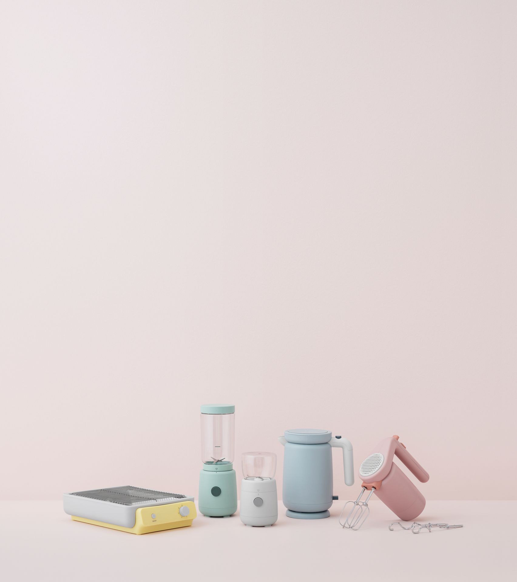 Hellrosa Handrührgerät von RIG TIG by Stelton, Küchengeräte in Pastellfarben auf rosa Hintergrund.