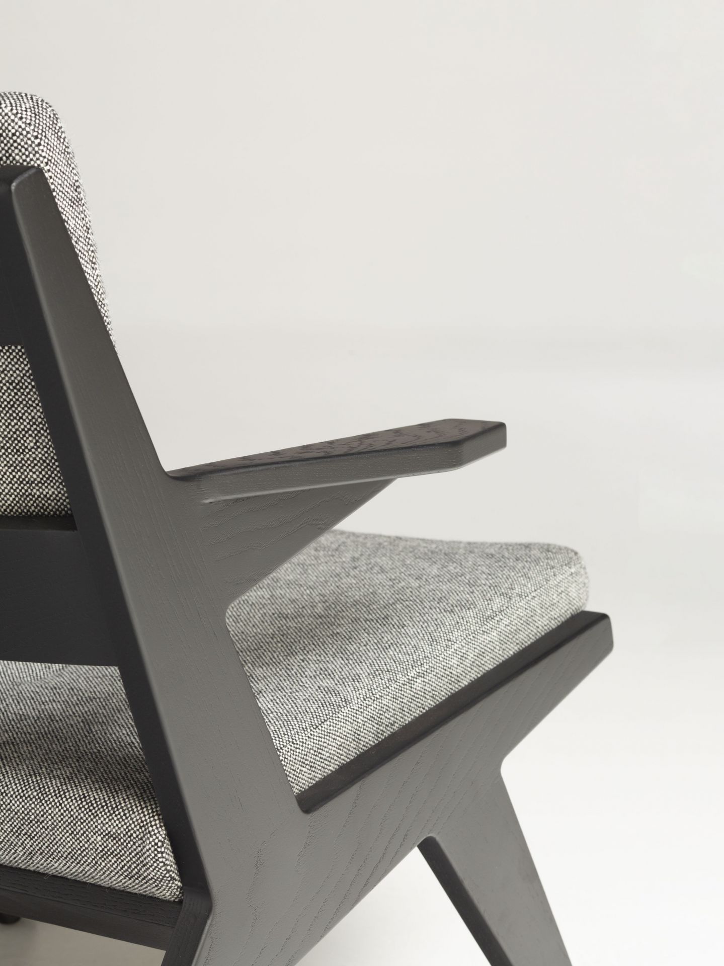 Detailaufnahme des Toggle Sessels von Prostoria mit grauem Stoffbezug und dunklem Holzgestell.