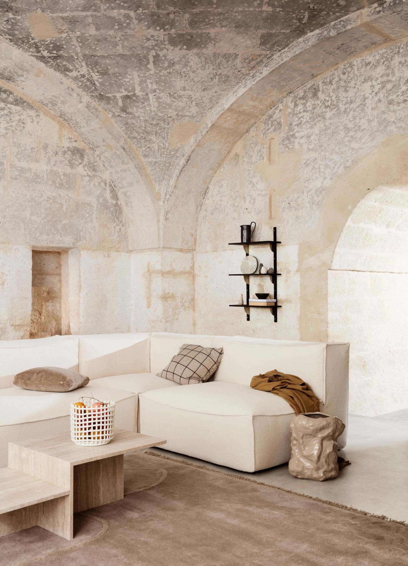 Distinct Couchtisch aus Travertin von Ferm Living im modernen Wohnzimmer mit Sofa und Teppich.