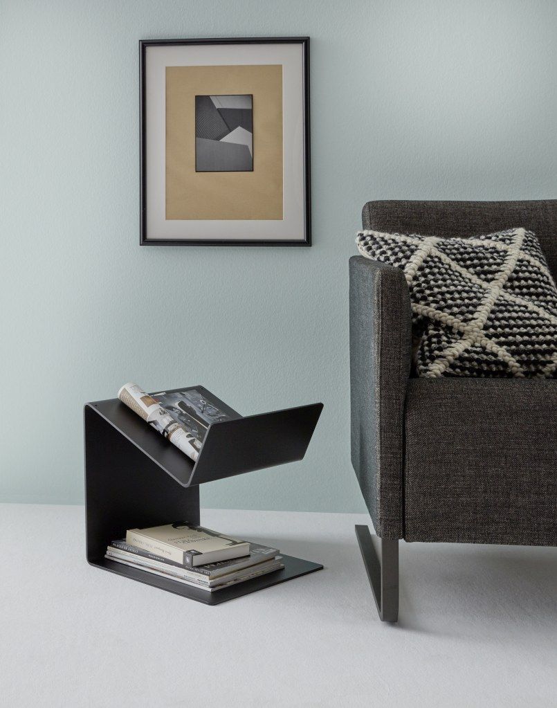 Schwarzer Buk Beistelltisch von Müller Möbelwerkstätten neben einem grauen Sessel mit Kissen.