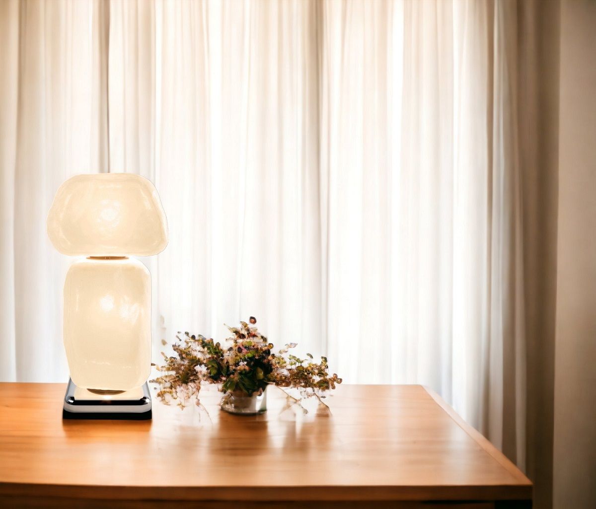 Nahaufnahme der Cassina Stone Light Tischleuchte auf einem Holztisch mit Vorhang im Hintergrund.