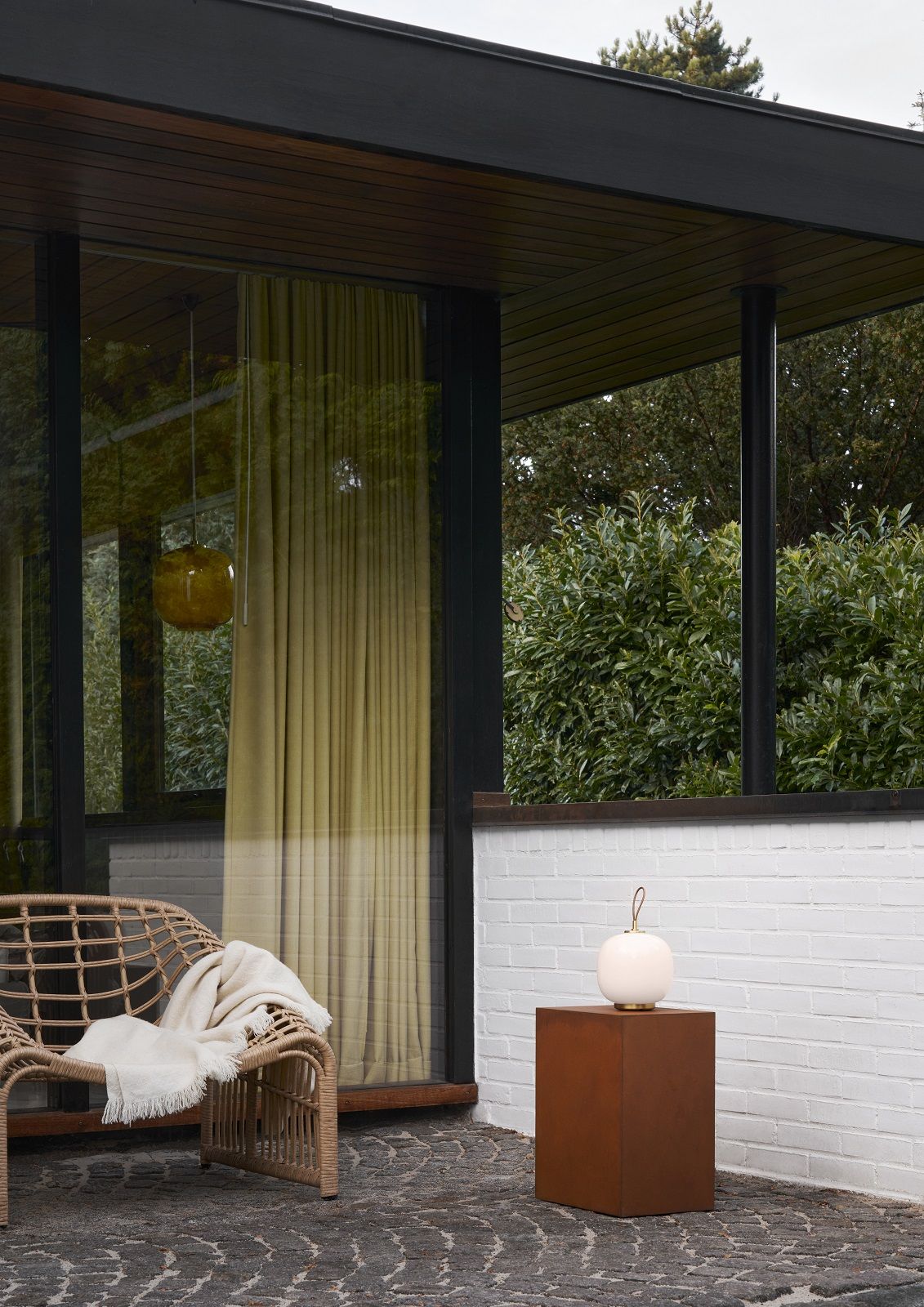 VL 45 Radiohus Tischleuchte von Louis Poulsen als Akku-Version auf einem Sockel im Außenbereich.