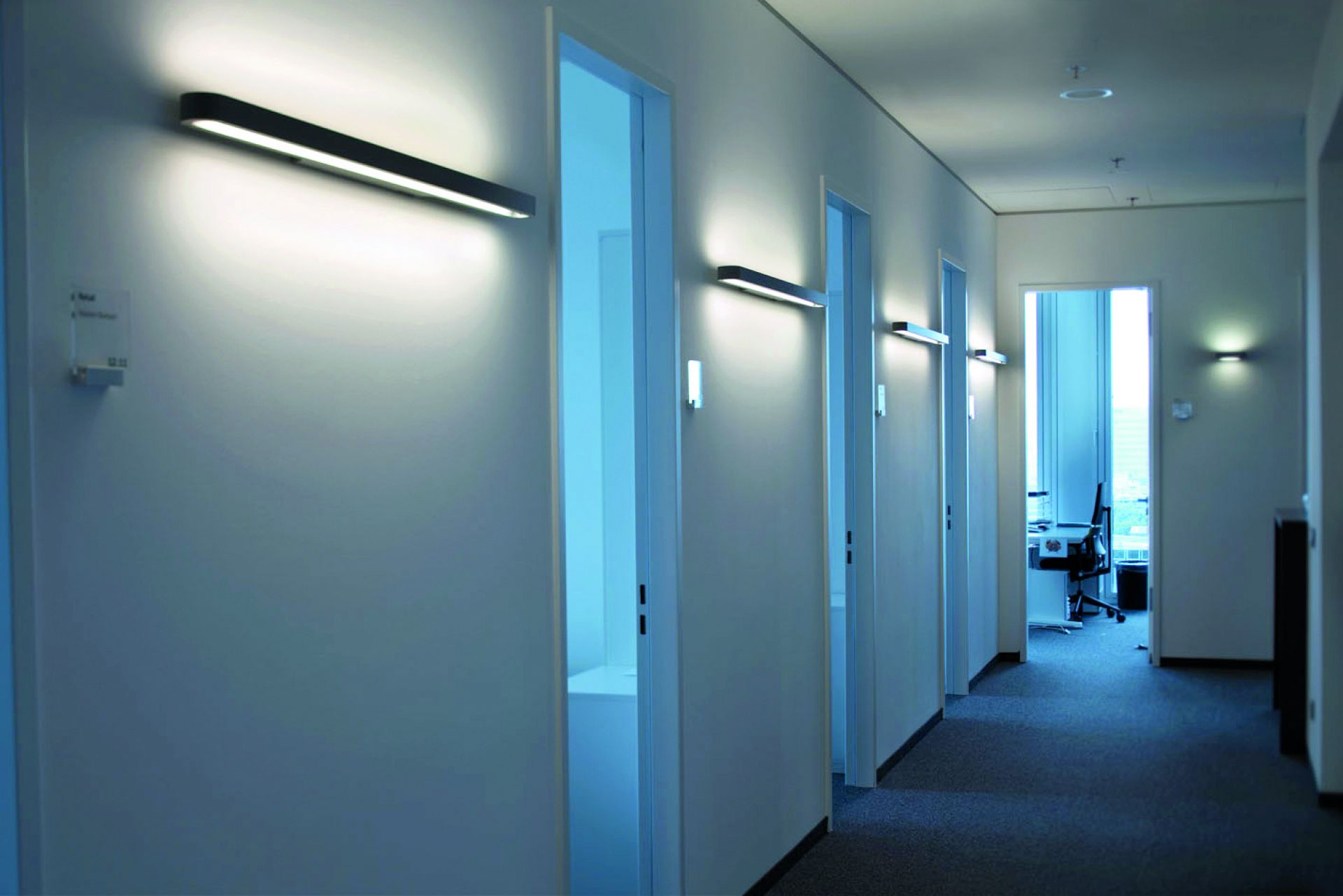 Flur mit mehreren Talo LED Wandleuchten von Artemide, moderne Innenbeleuchtung für Büro und Zuhause.