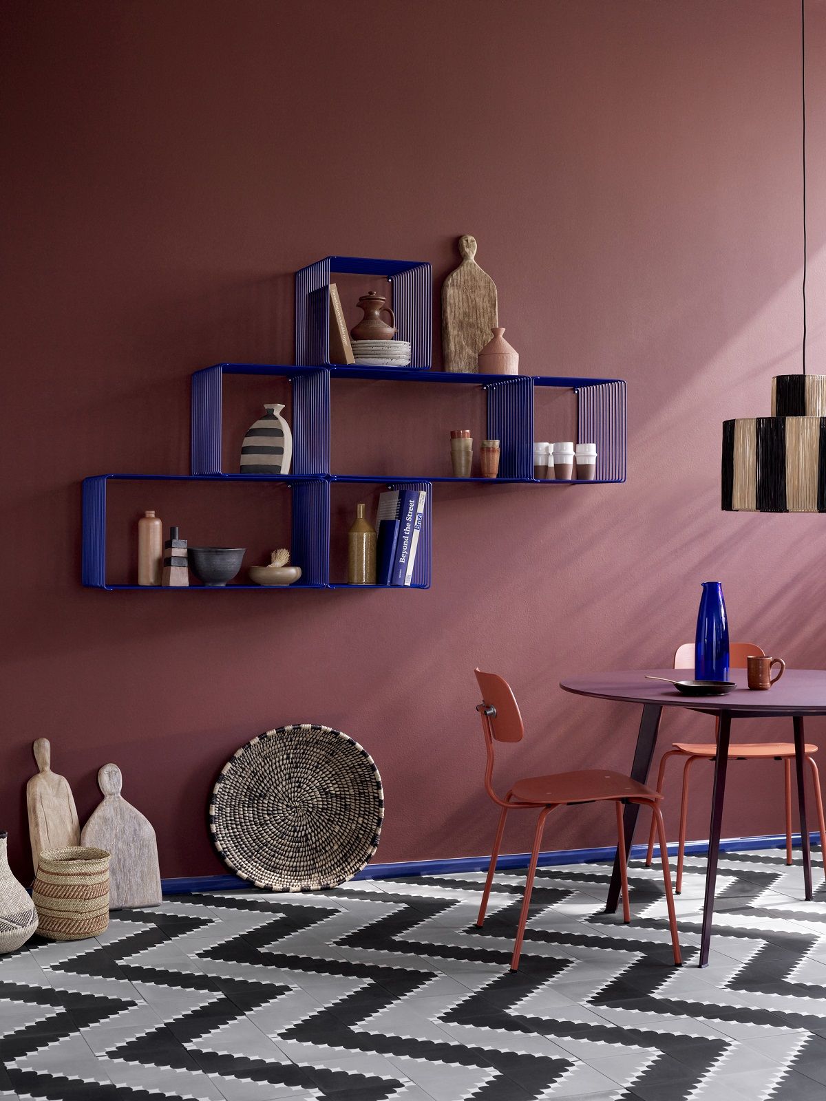 Blaues Panton Wire Regalsystem von Montana an einer farbigen Wand mit Deko-Objekten.