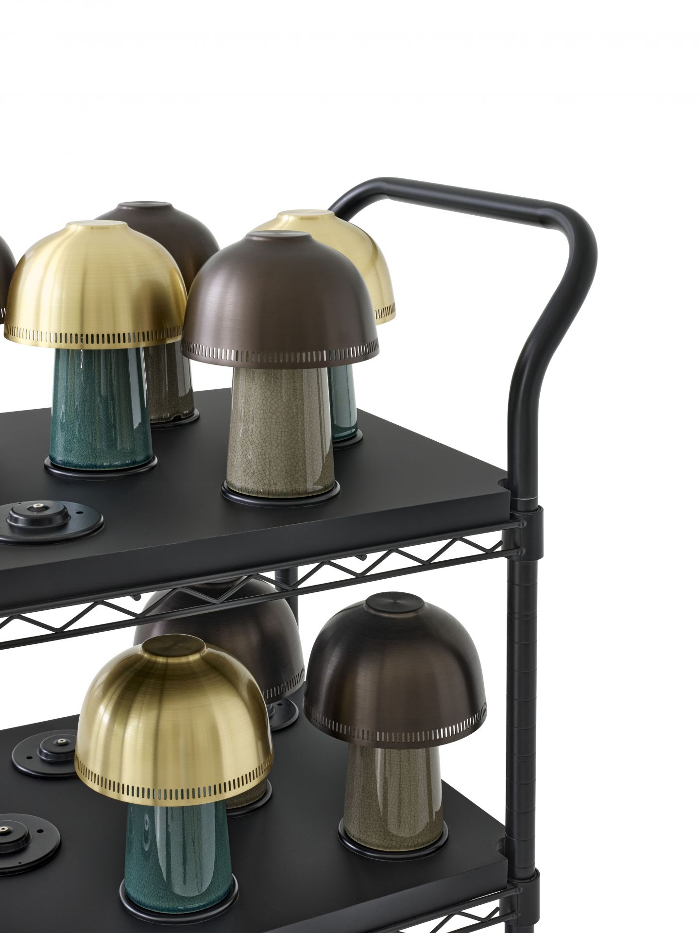 AndTradition Raku SH8 Akkuleuchte auf einem schwarzen Regal, goldene und braune Lampenschirme.