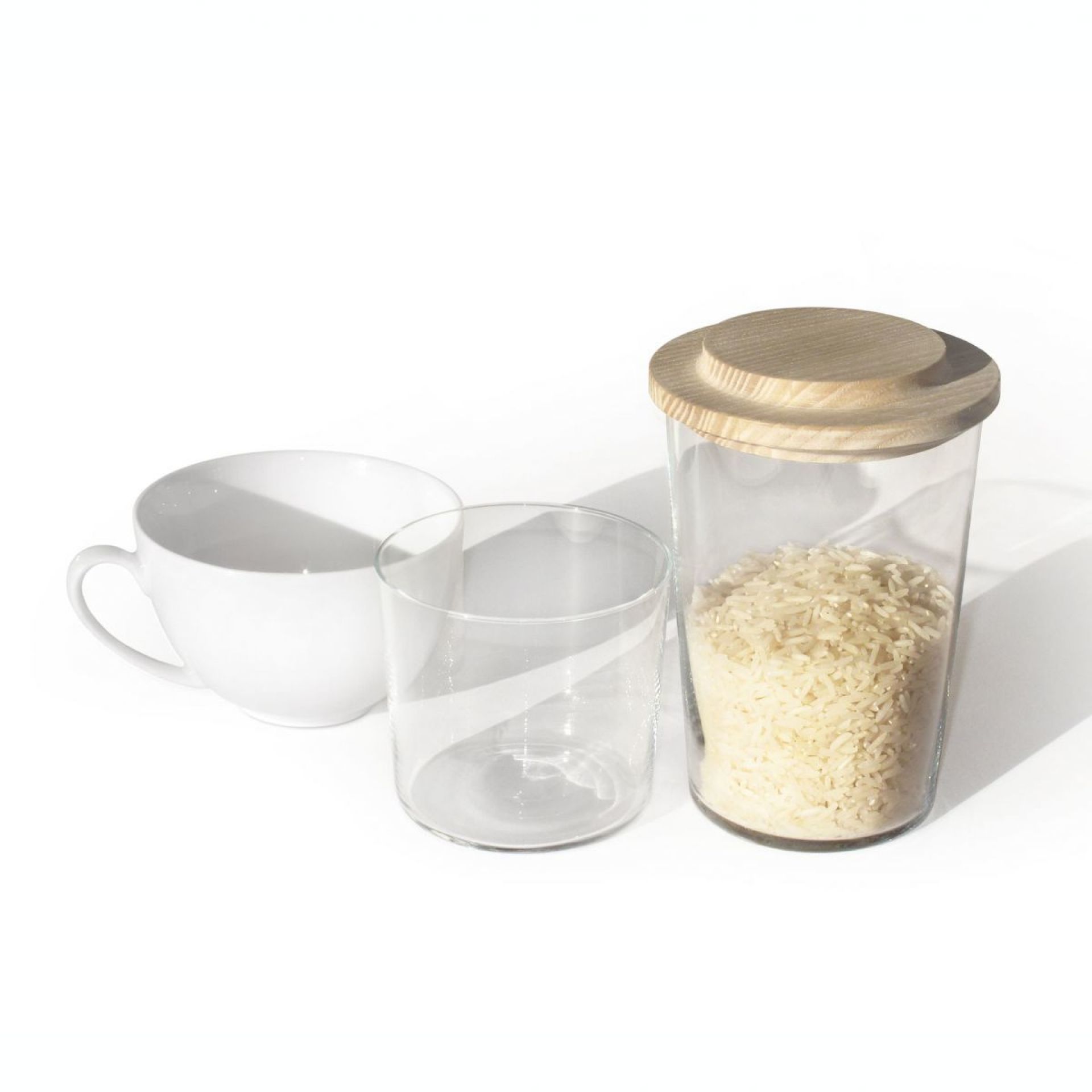 Glasbehälter mit Reis und OH, GUT Holzdeckel, neben Tasse und Glas.