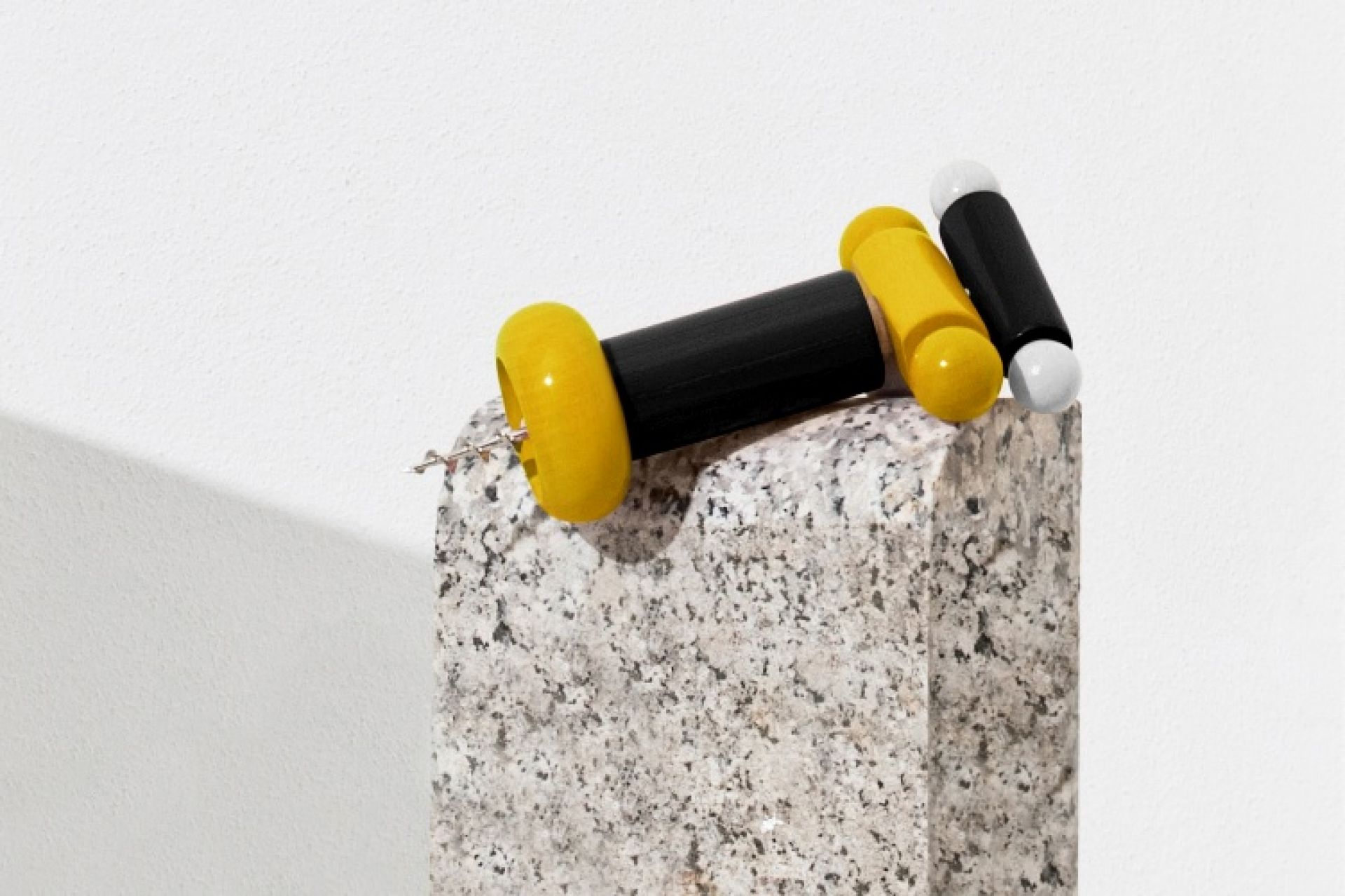 Alessi Korkenzieher ES17, gelb und schwarz, auf einem Steinsockel. Design Korkenzieher für Weinliebhaber.