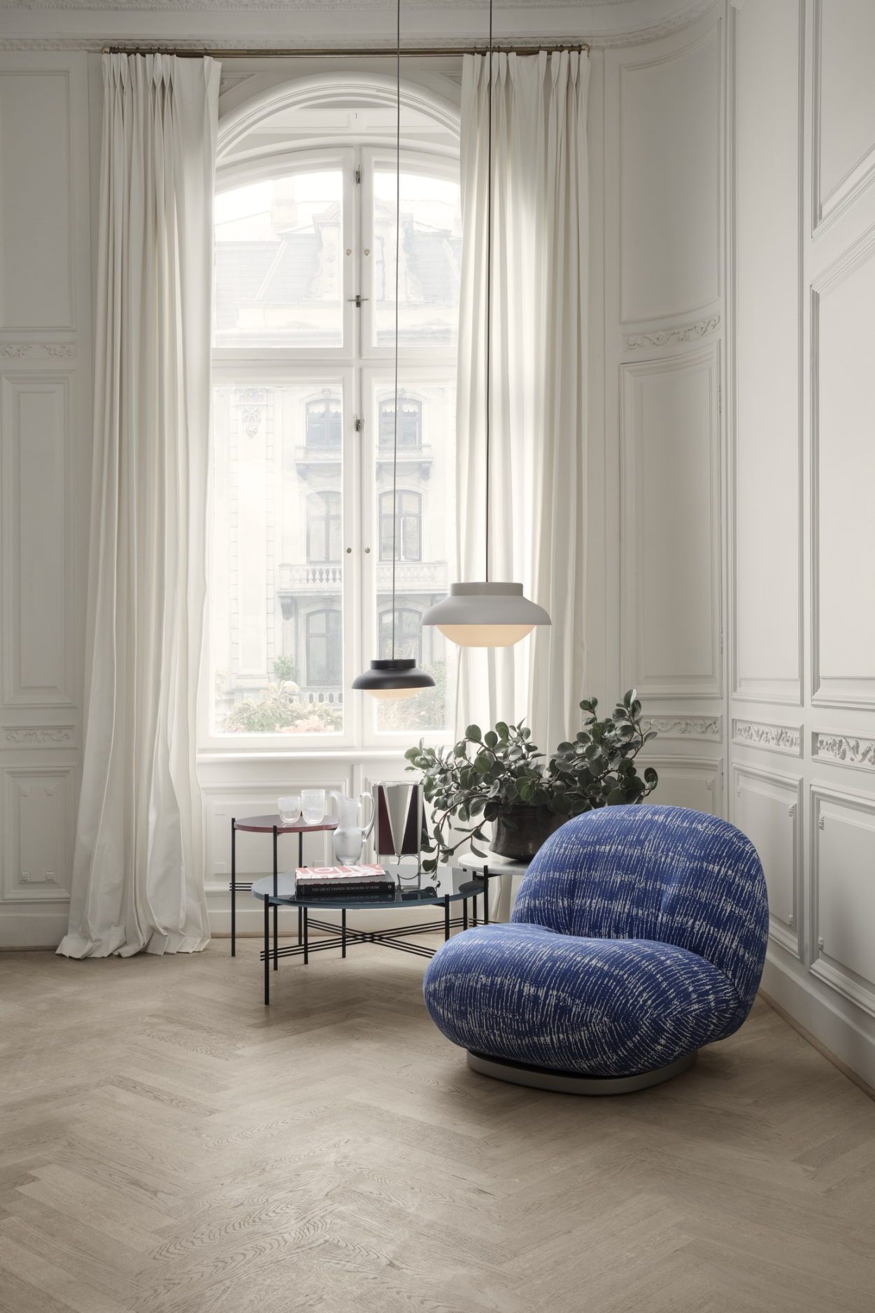 TS Beistelltisch von Gubi mit schwarzer Marmorplatte in stilvollem Wohnzimmerambiente, ergänzt durch Designermöbel und Pendelleuchten.