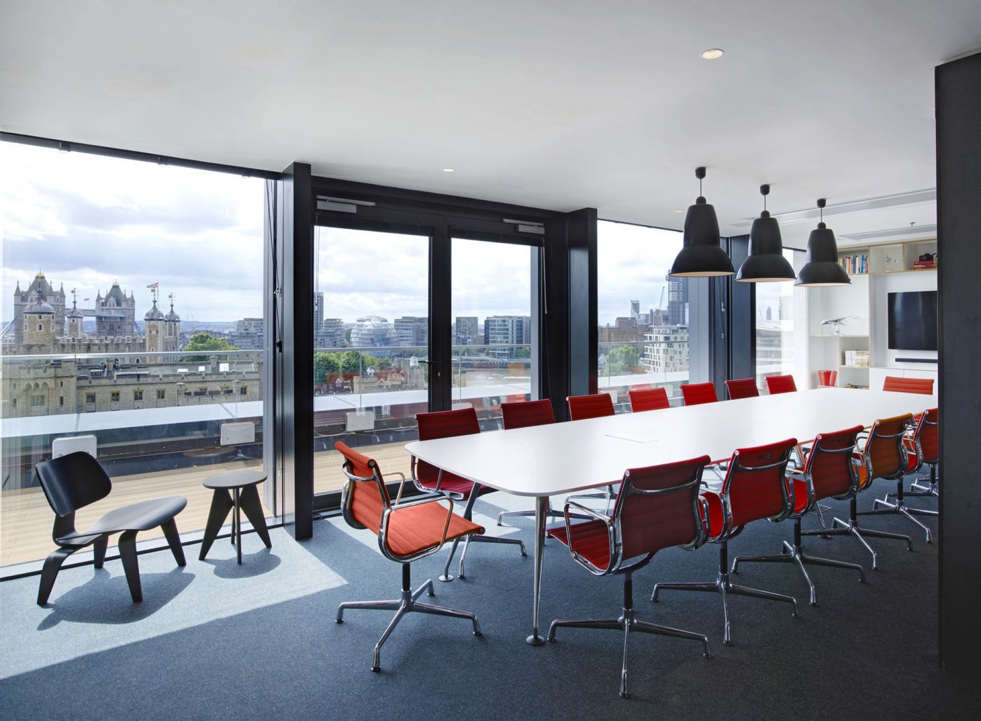 Vitra Plywood Group LCW Stuhl in modernem Büro mit Blick auf Londoner Skyline. Designklassiker Möbel.