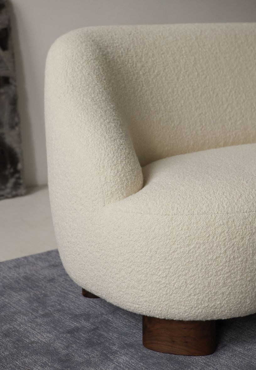 Detailaufnahme des Margas Sofas von AndTradition: Cremefarbenes 2-Sitzer Sofa mit Bouclé-Bezug und Holzfüßen.