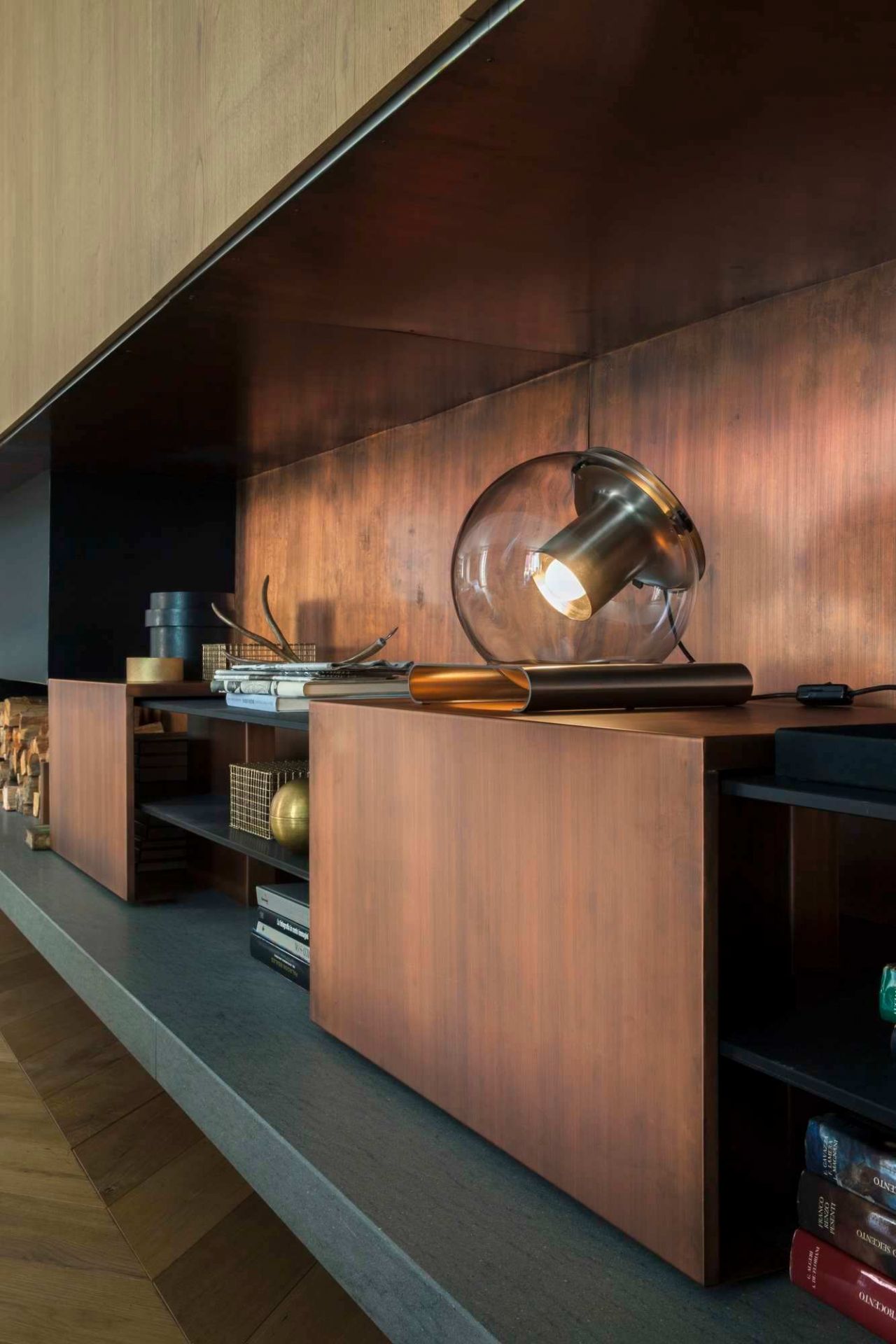 The Globe Tischleuchte 228 von Oluce auf einem Regal mit Kupferverkleidung, modernes Design.