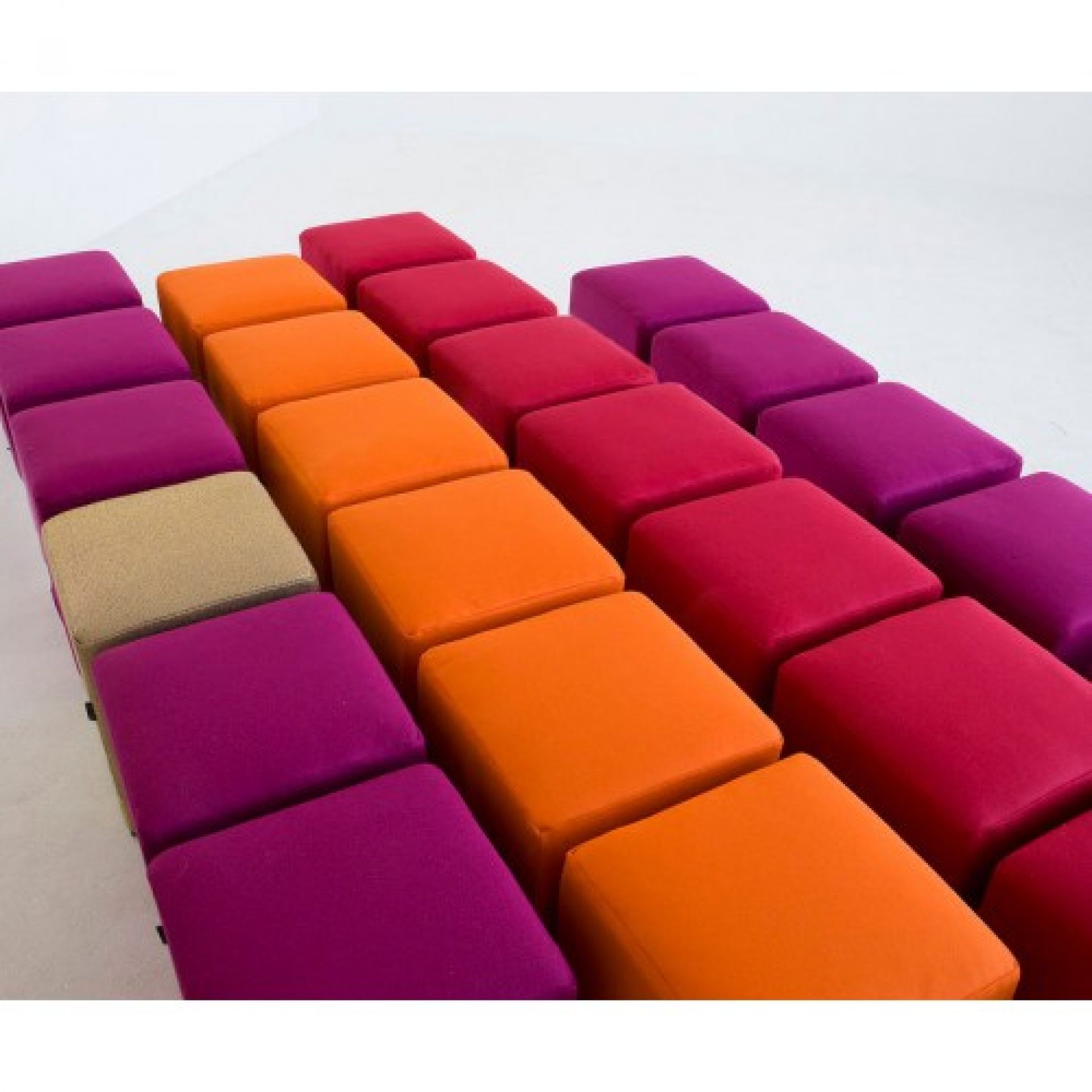 Reihe von bunten Softline Pouf Hockern in Orange, Pink, Rot und Beige.